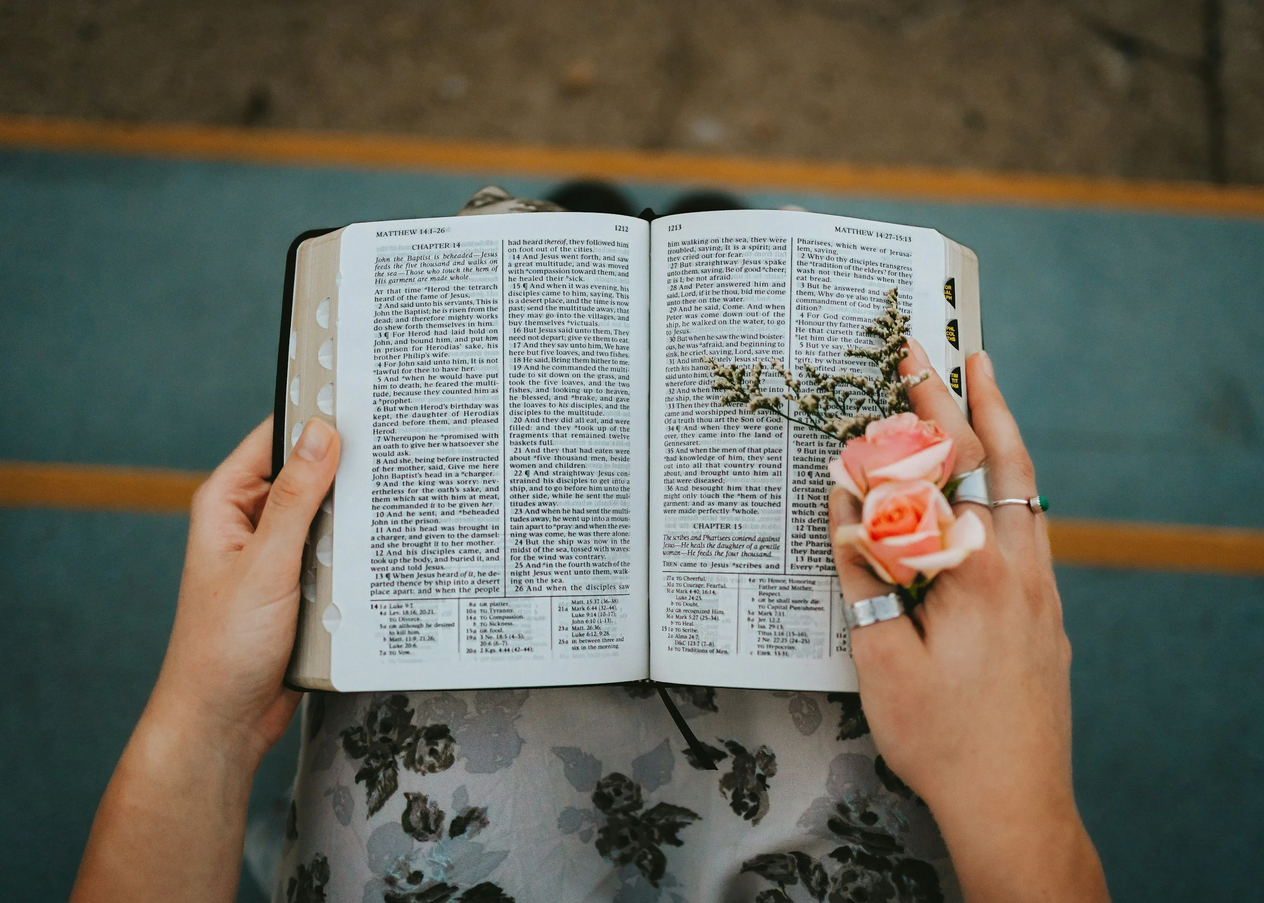 A wedding Bible open with a small bouquet of pink roses laid on top of it.
