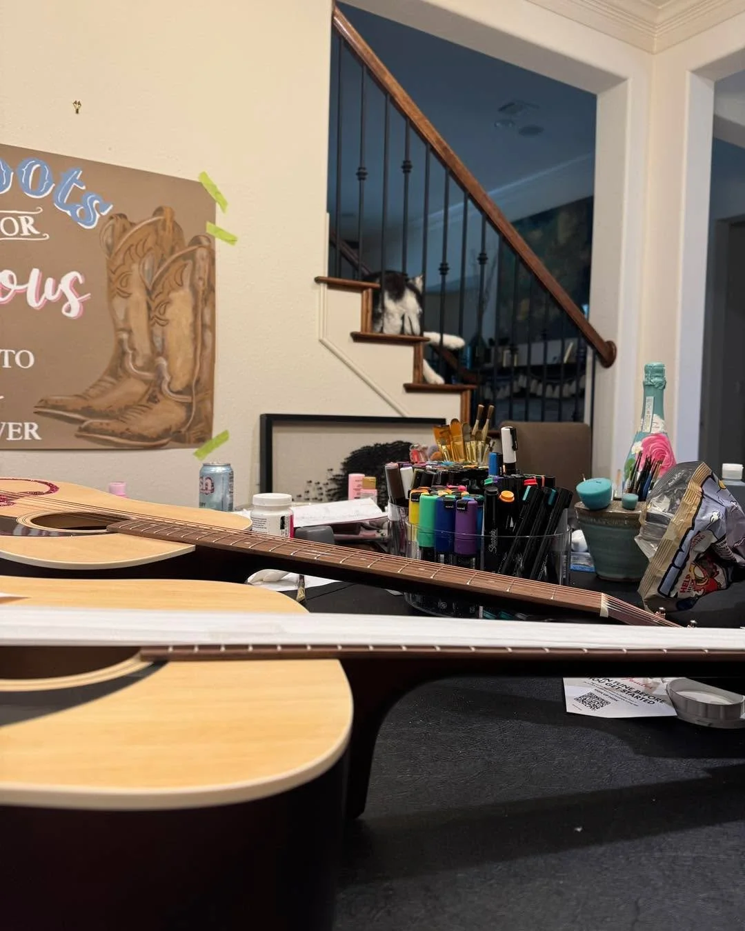 What does running Wise Market look like today?

One drying, one guitar waiting on paint.
A banner drying on the wall.
A champagne bottle in progress.
A dining room table doing the absolute most.
And Indi, my supervisor, overseeing it all from the sta