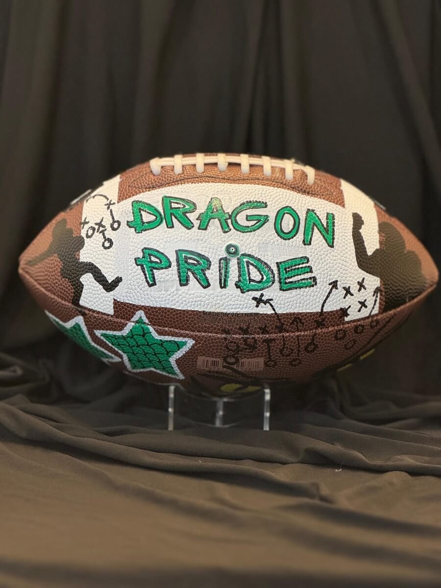 Custom football with "Dragon Pride" written in white and green, designed for a football team.