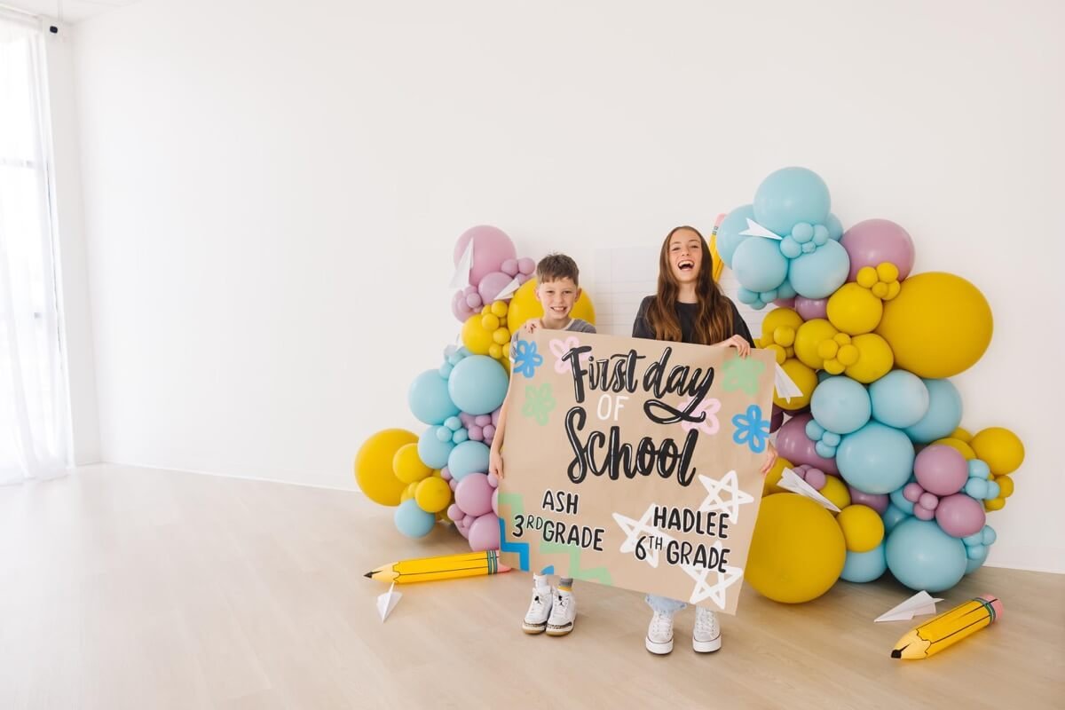 Custom back-to-school event banner with kids standing in front of bright decorations.