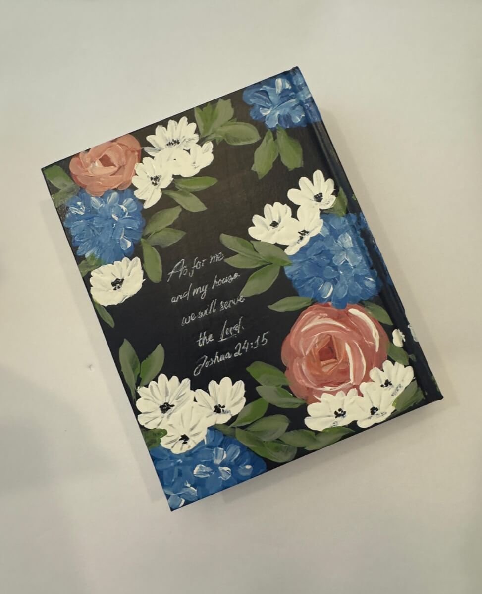 Custom hand-painted Bible with roses and hydrangeas, along with a personalized scripture on the back.