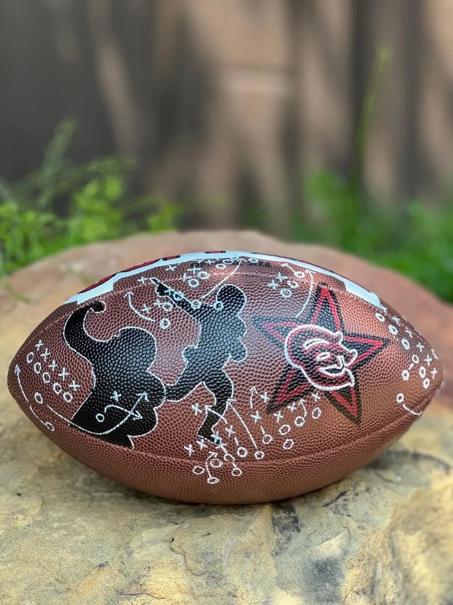 Custom football with black graphic images of football players, Xs and Os, and a black and red star logo.