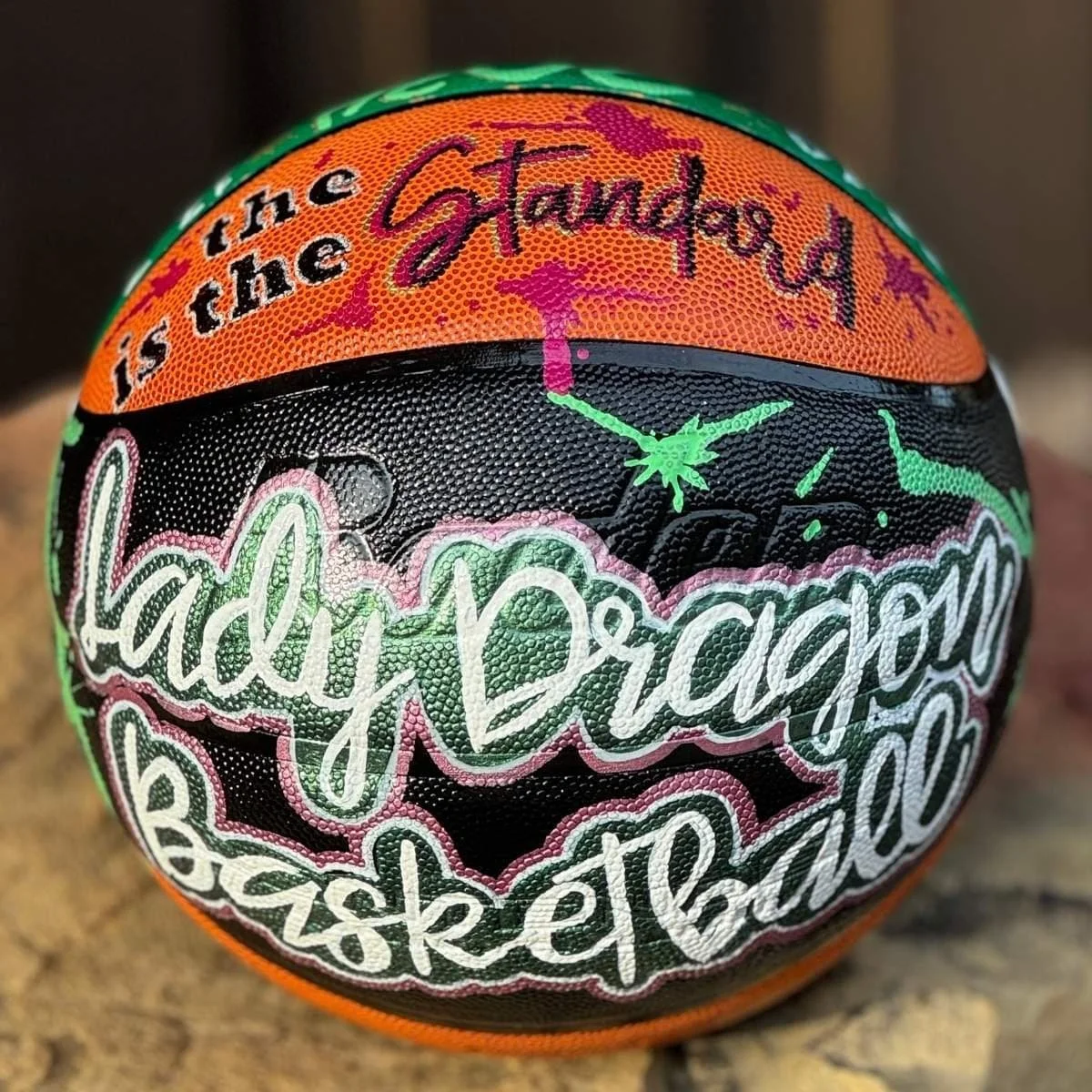 A colorful basketball with artistic graffiti-style text, including phrases like 'The is the Gland