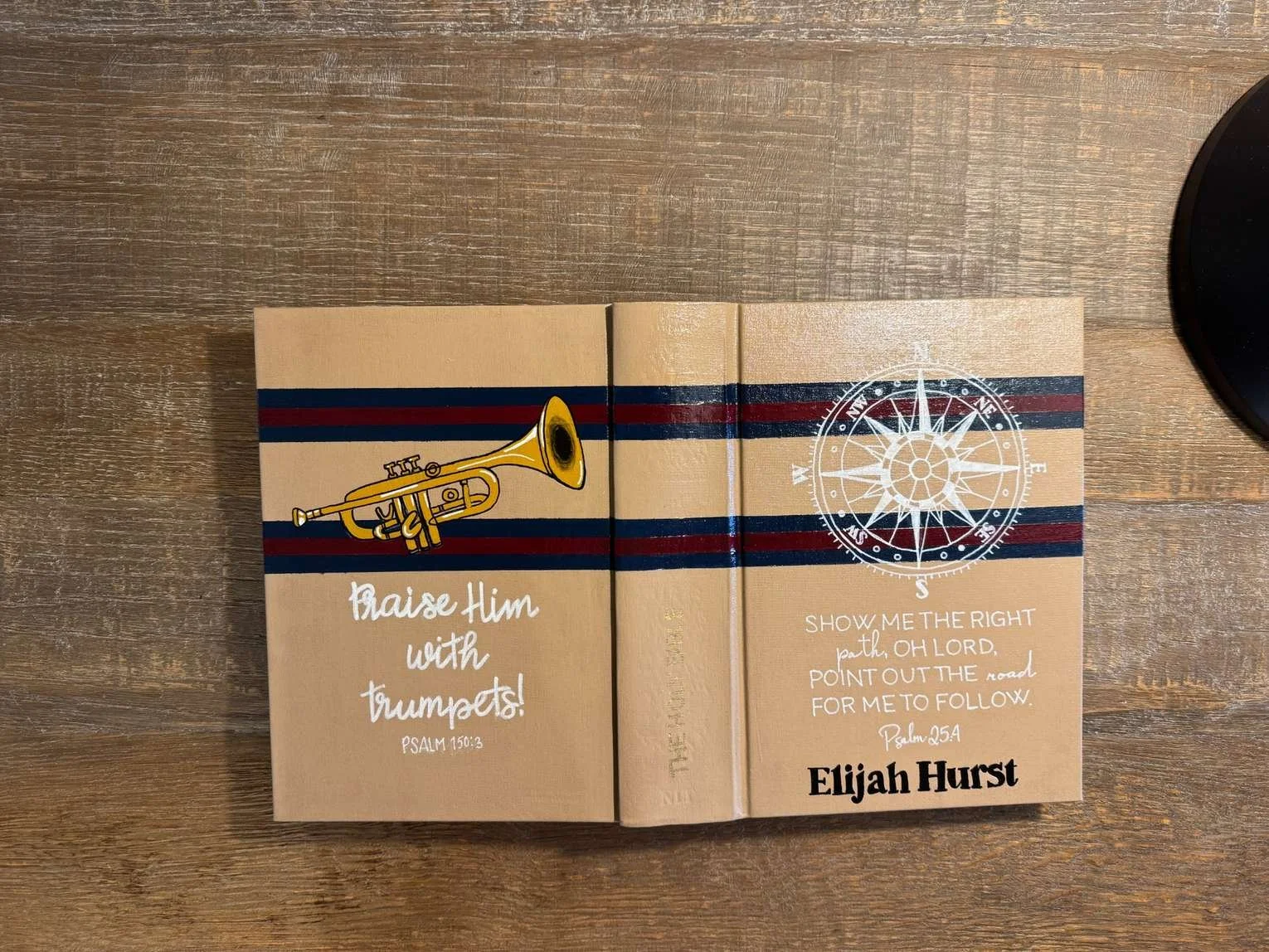 Custom hand-painted Bible featuring a trumpet, compass, personalized name and scripture for a young man.