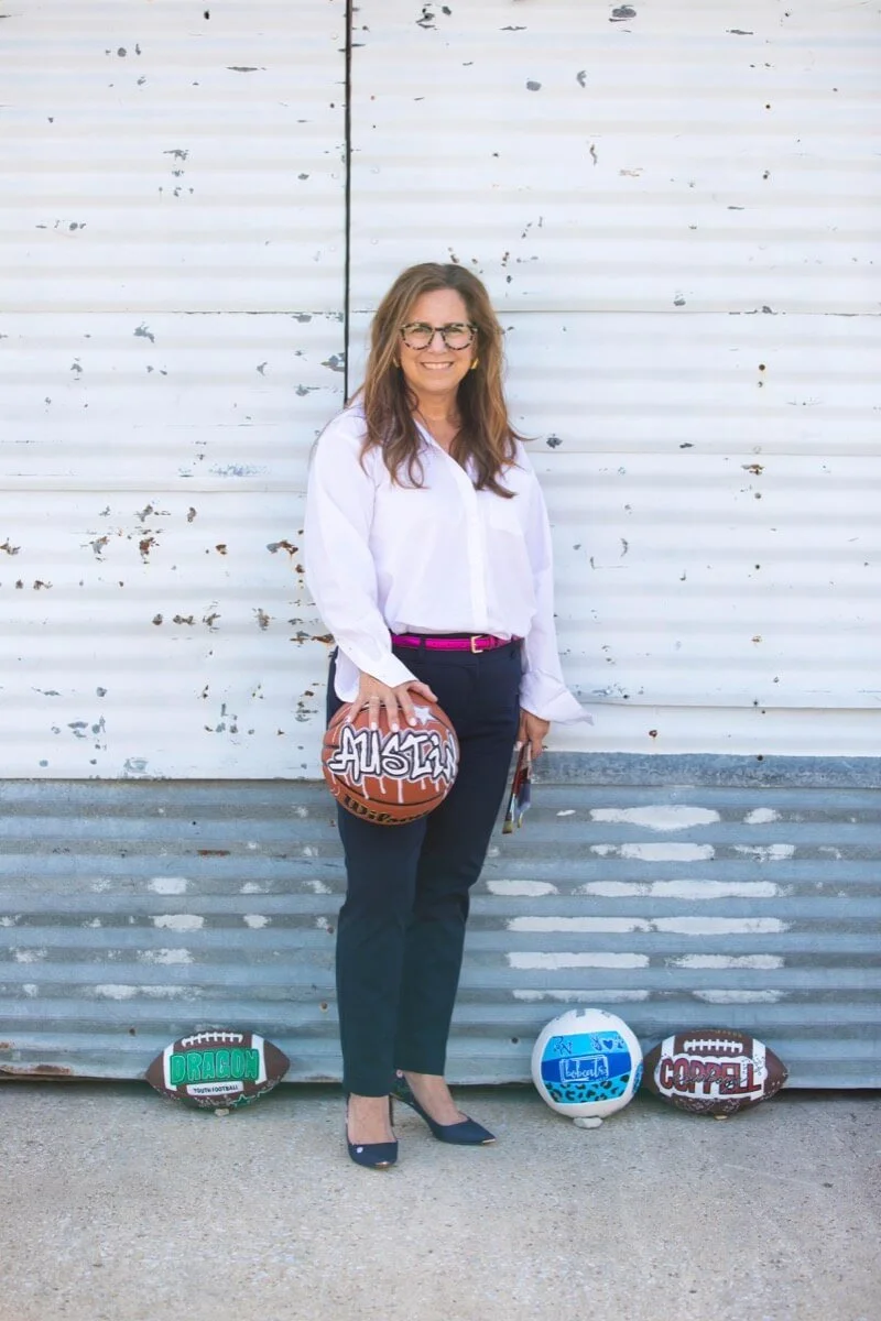 artist holding hand painted personalized basketball and brushes