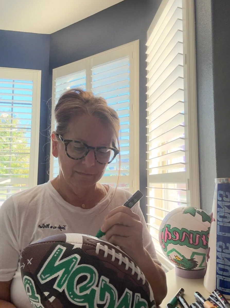 artist at work hand painting a football in studio