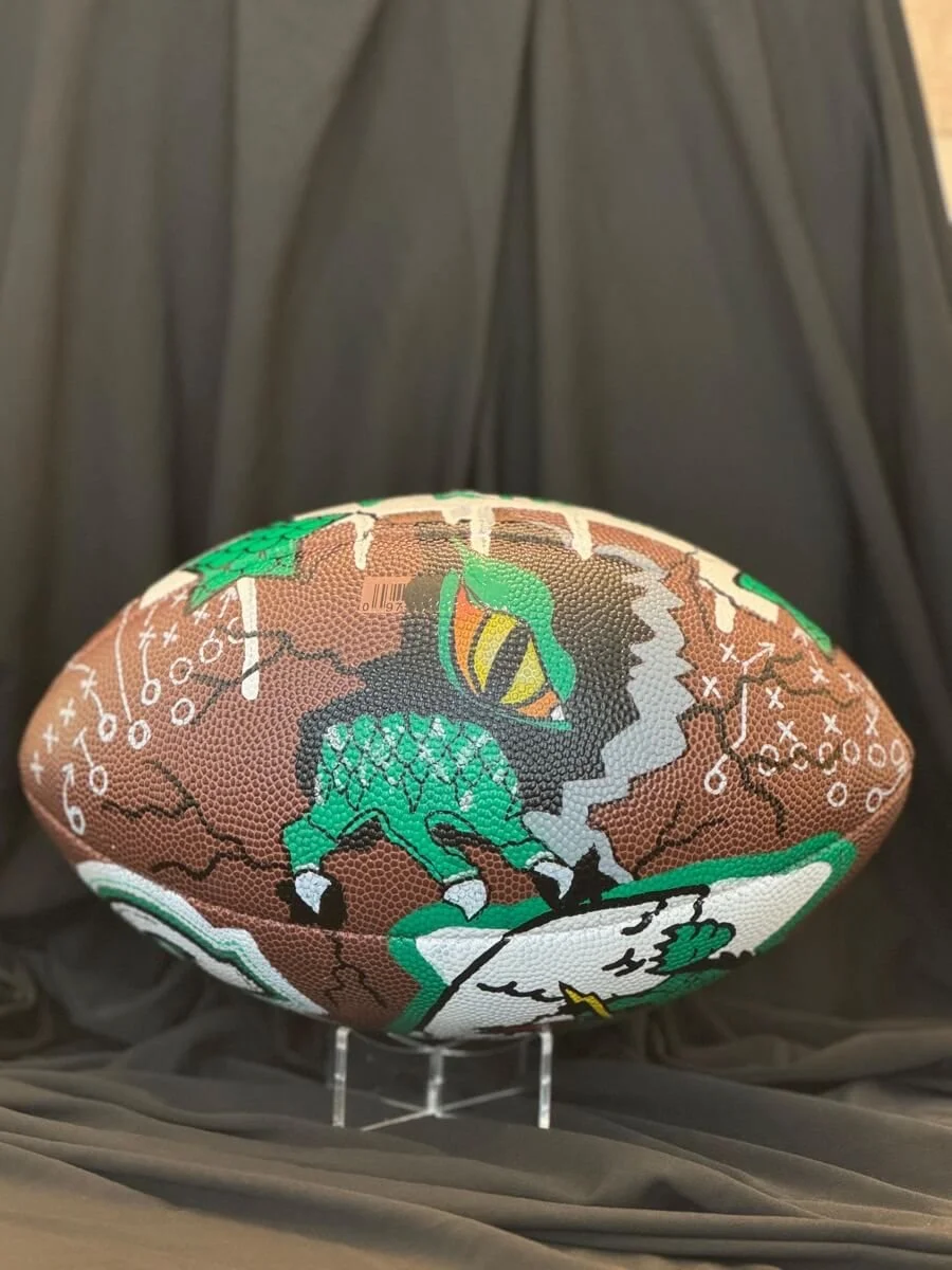 Custom football with a scene of a dragon eye and its claw tearing through the ball.