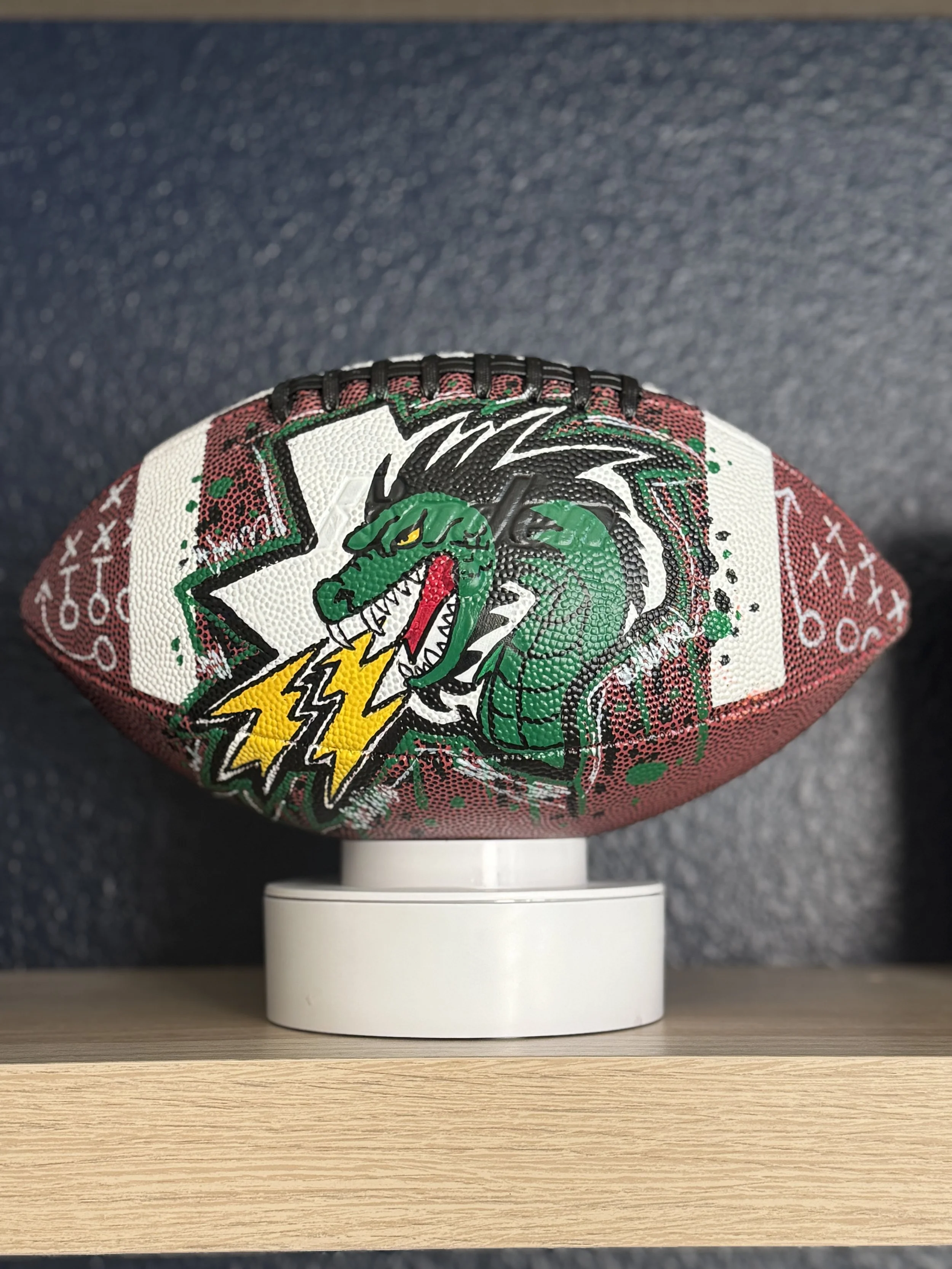Hand-painted custom football featuring a green dragon mascot and lightning bolt design