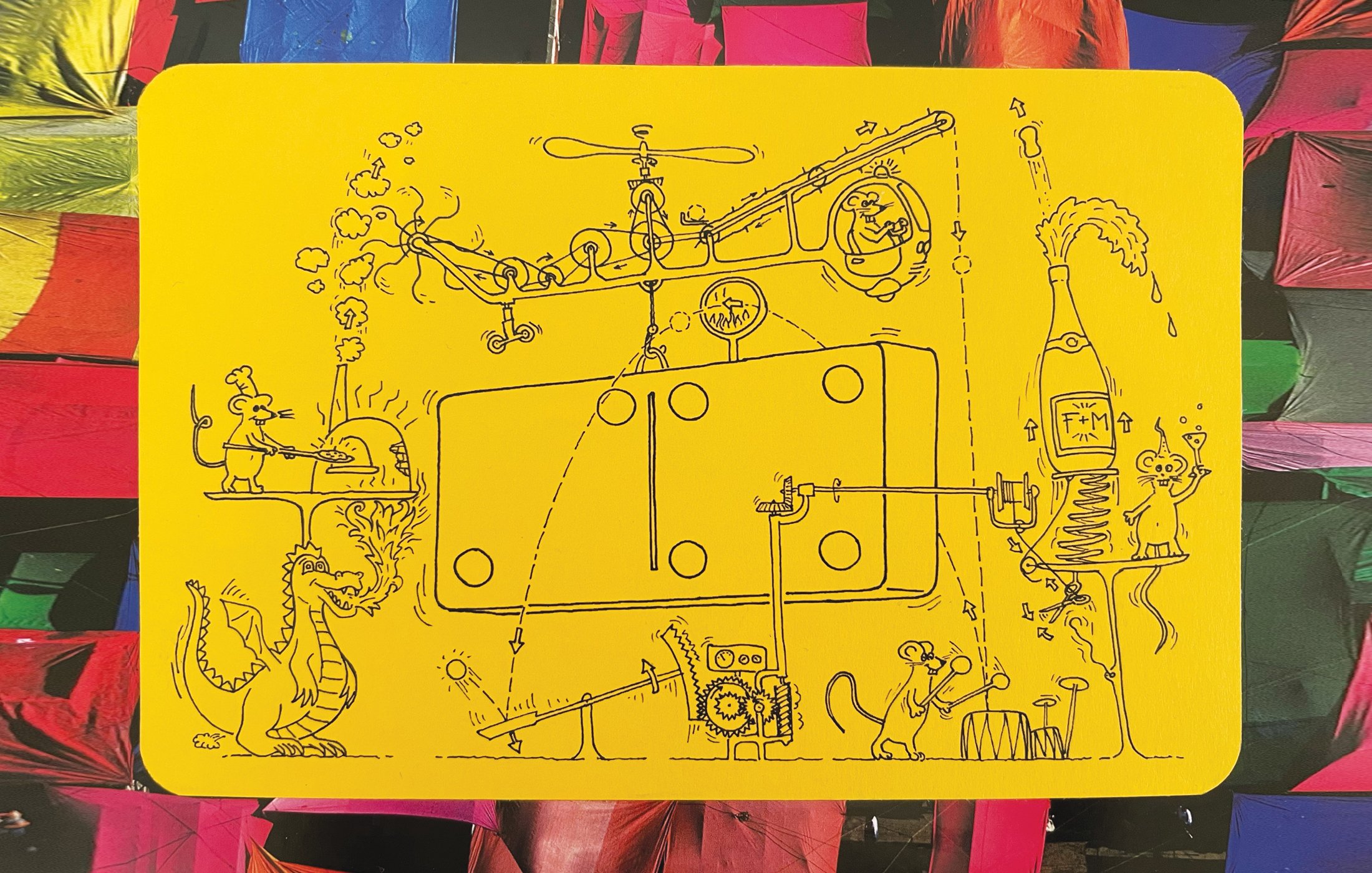 2024: After 13 years, we have many old spare cards that I wanted to reuse. I bought a 2nd hand book with large photos and used them to cover previous illustrations. Fabian drew a contraption inspired by Rube Goldberg and Tinguely machines. The domino