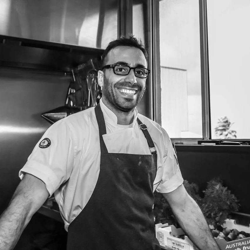 Francesco Valente wearing an apron in a kitchen environment