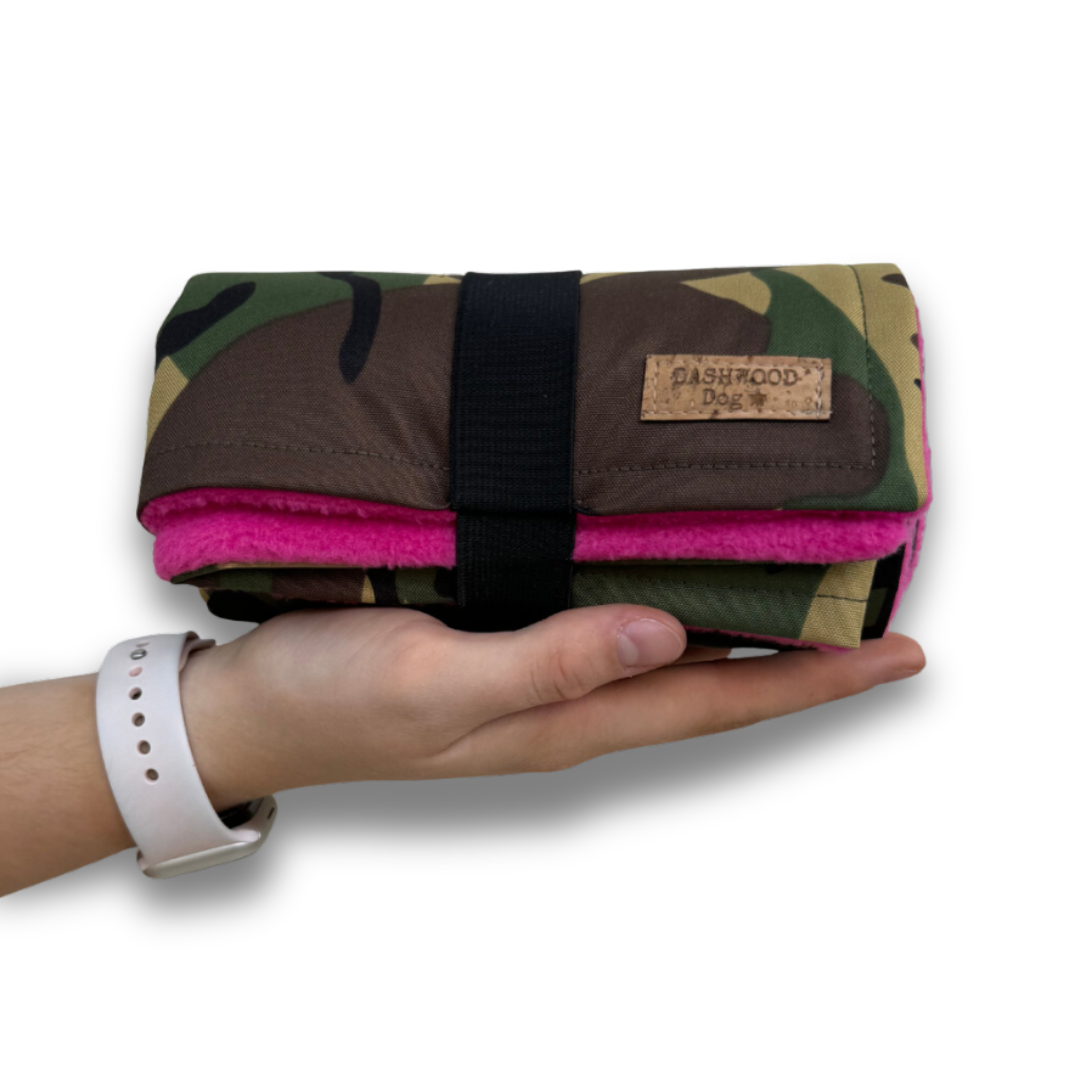 Human hand colding the Dashwood Dog waterproof fleece-lined settle mat