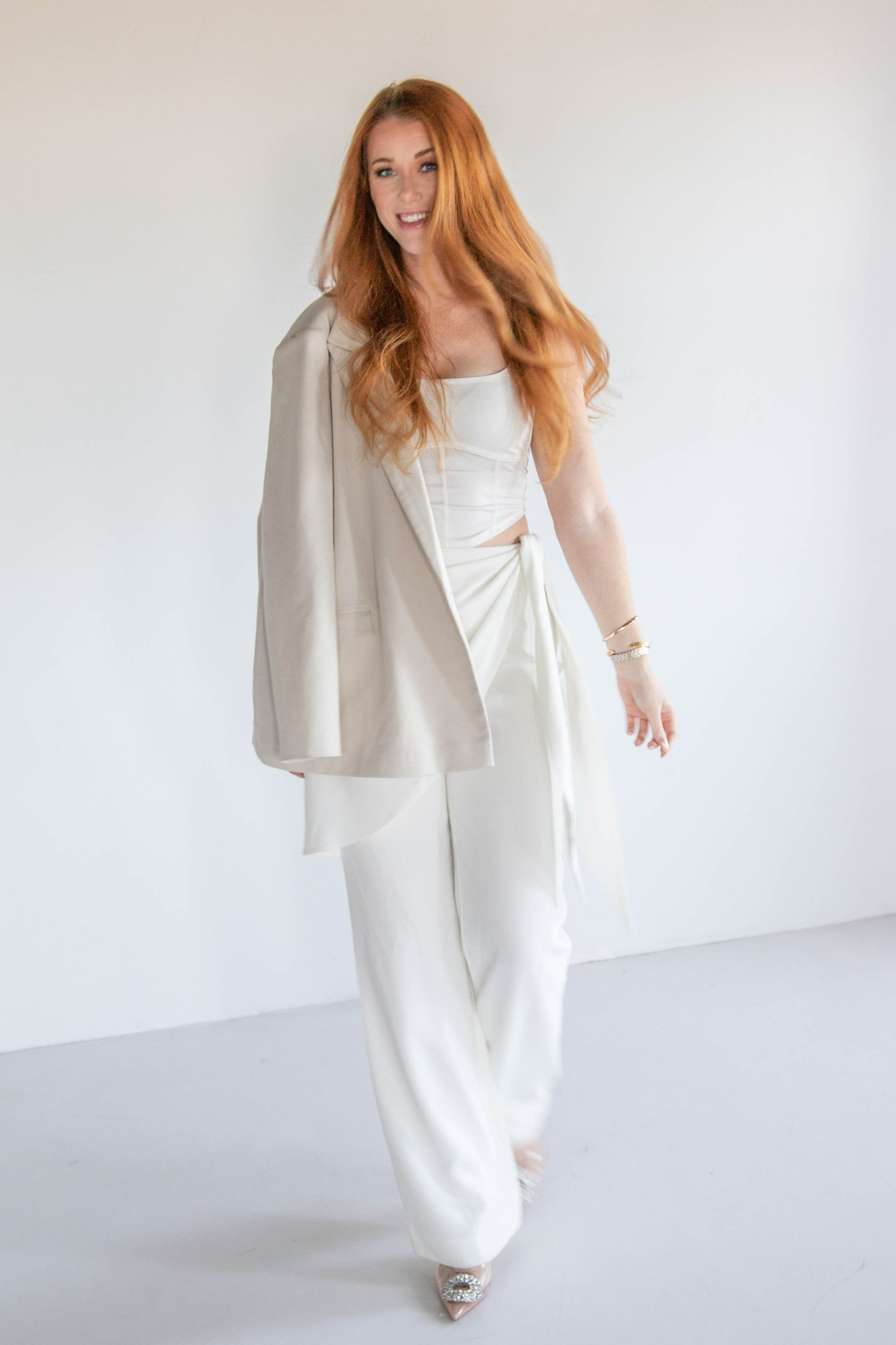 Alyssa Warring, founder and principal designer of Wren House Design, dressed in modern white outfit with soft neutral tones – approachable Arizona interior designer specializing in Western Organic Modern homes.