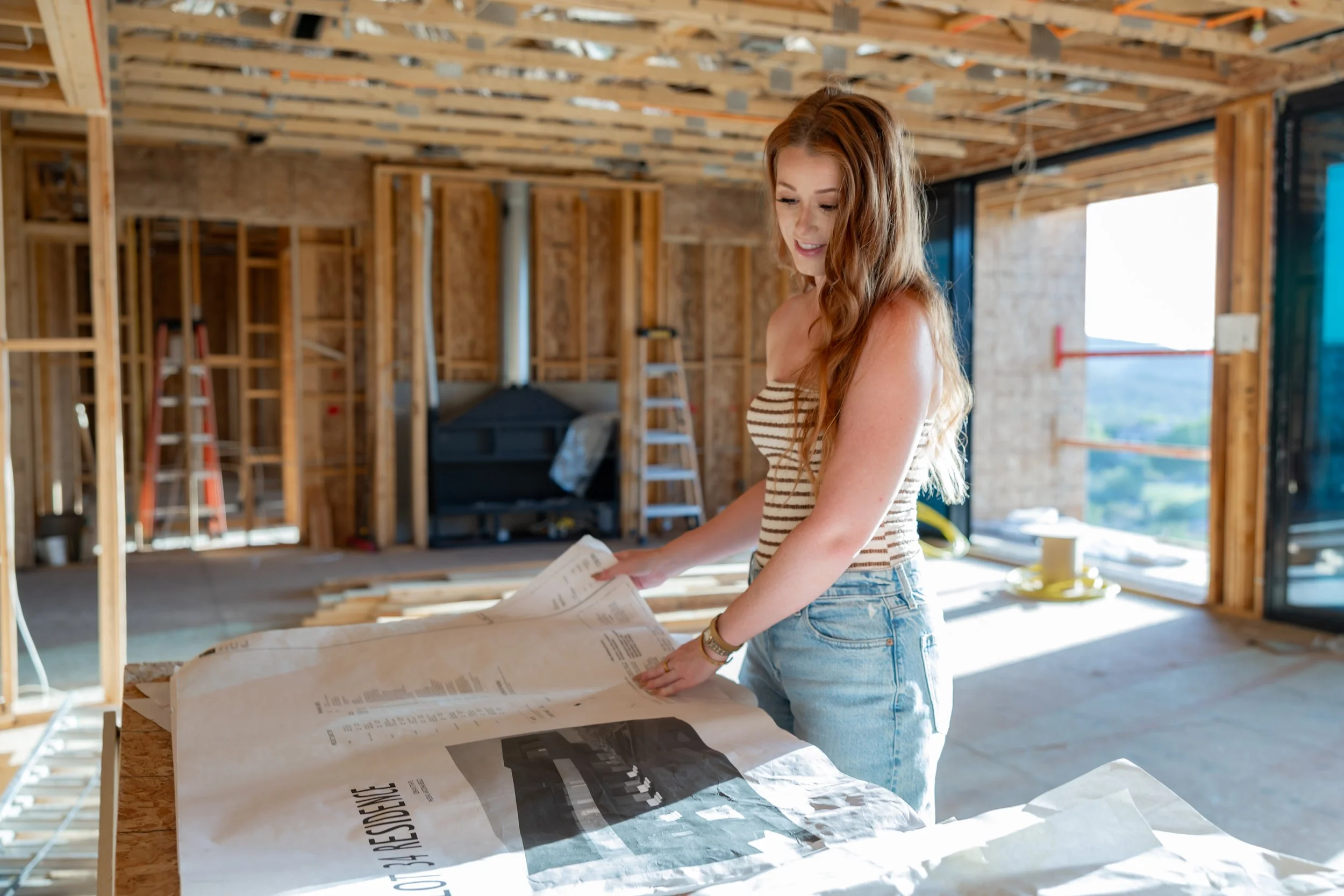 Alyssa Warring, Arizona interior designer and founder of Wren House Design, reviewing architectural plans on-site during custom home construction – Western Organic Modern design process.