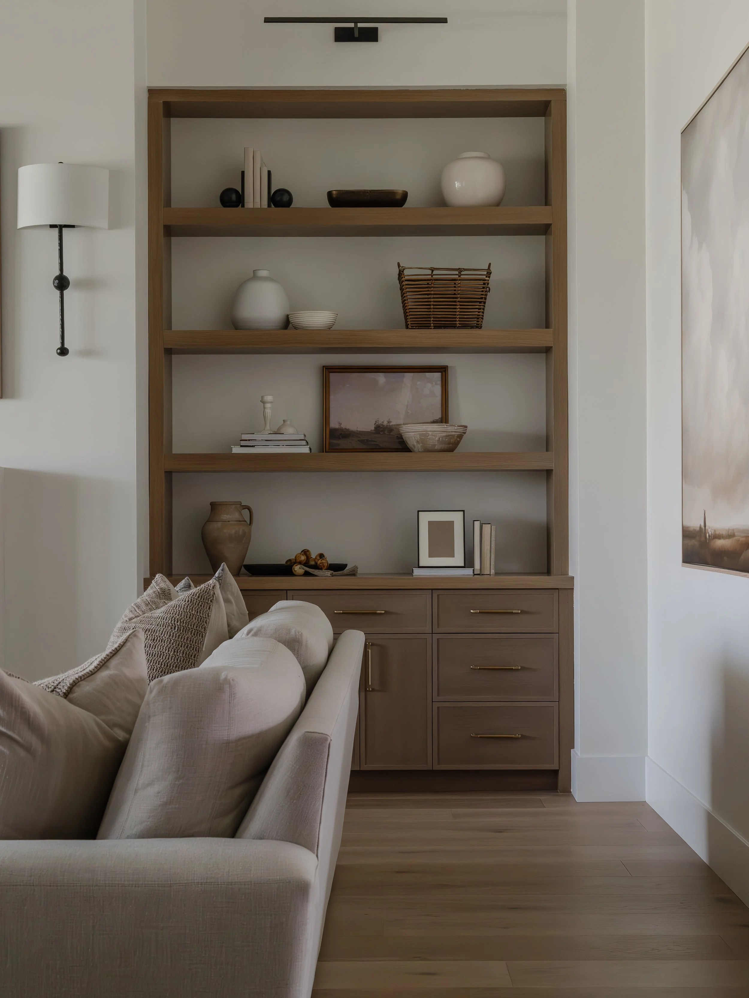 Western Organic Modern design details – textured stone vessels styled on wood and custom built-in shelving with curated decor, neutral tones, and natural materials by Wren House Design in Arizona.”
