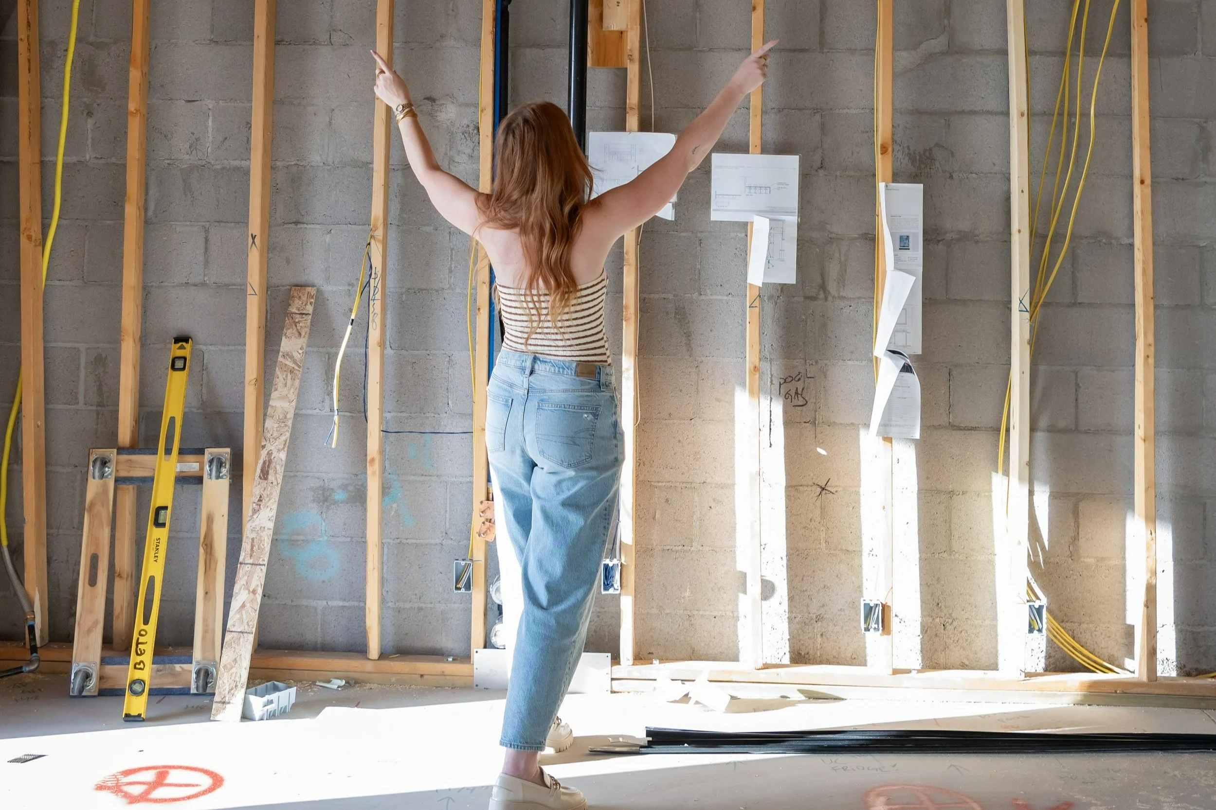 Wren House Design behind the scenes – Alyssa Warring marking construction framing during Arizona custom home build, blending interior architecture and design expertise.