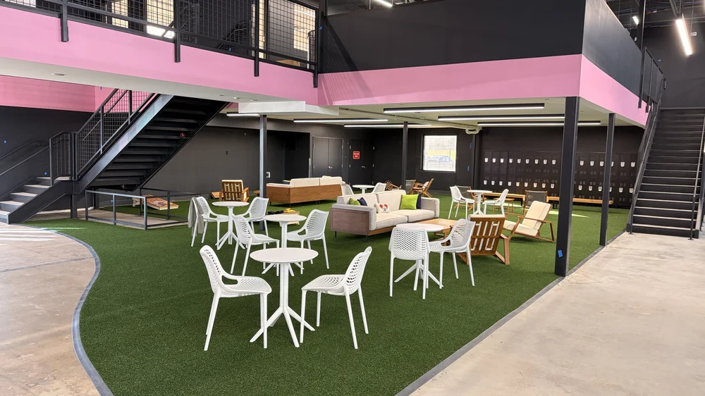 The turf lounge with seating under the pink mezzanine.