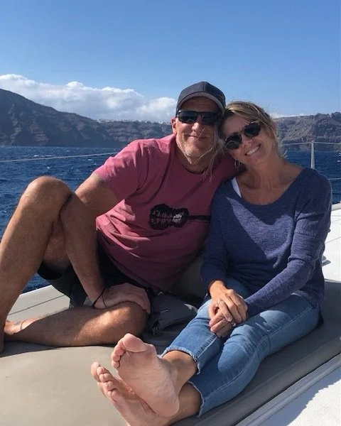 Couple sitting on a boat with mountains in the background.