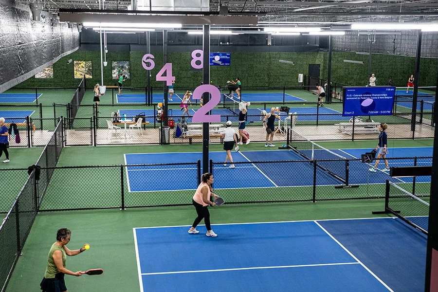 Players on several indoor courts during open play.