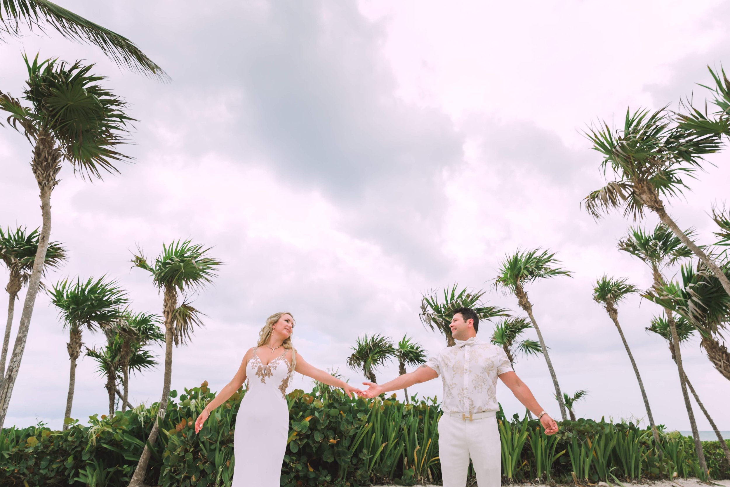 us holding hands with a clear sky and palm tress in back ground.JPG