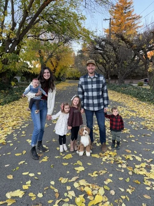 Our family of six and our sweet Bernedoodle posing outdoors on a fall day.