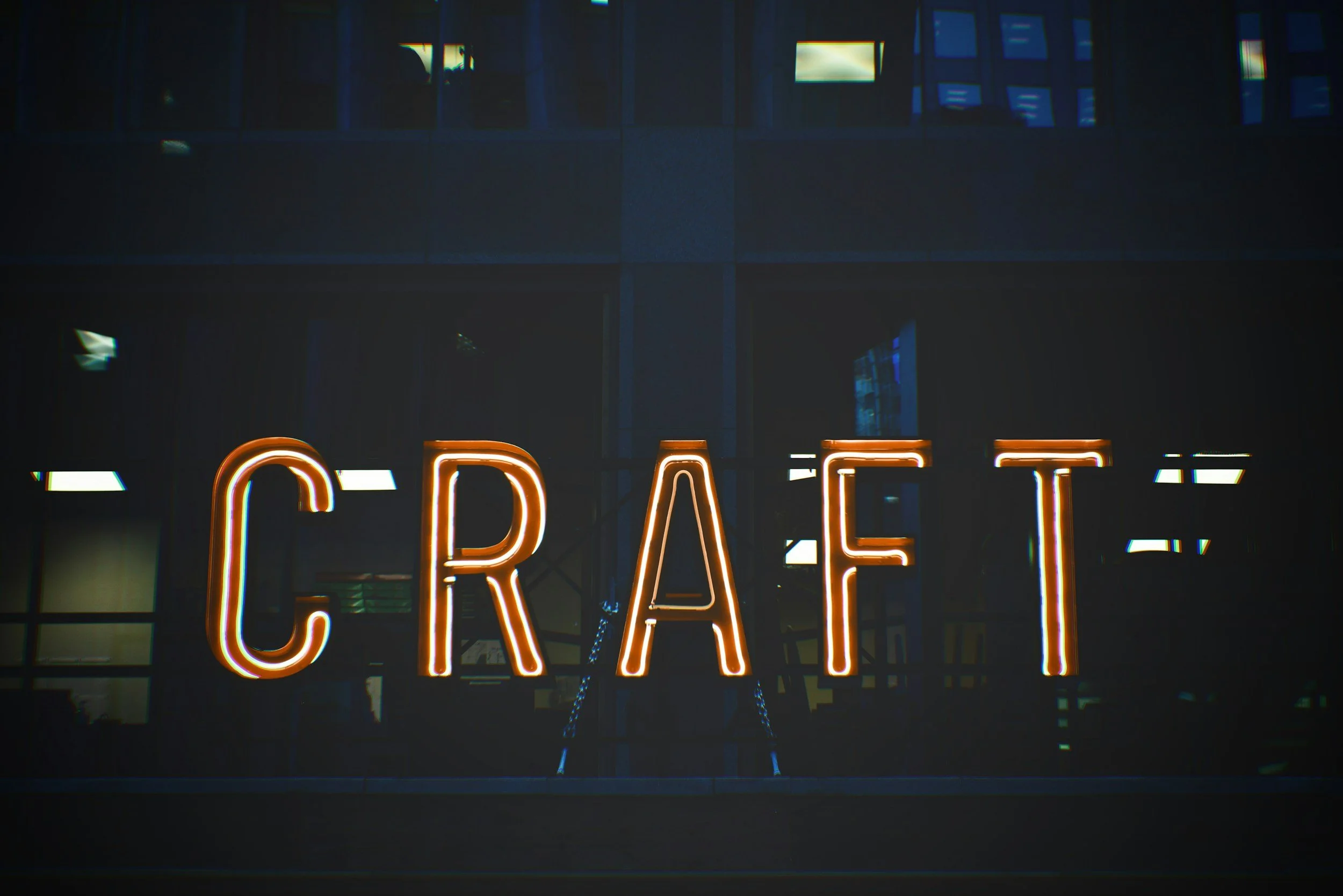 Neon sign spelling out the word 'CRAF' on a building at night.