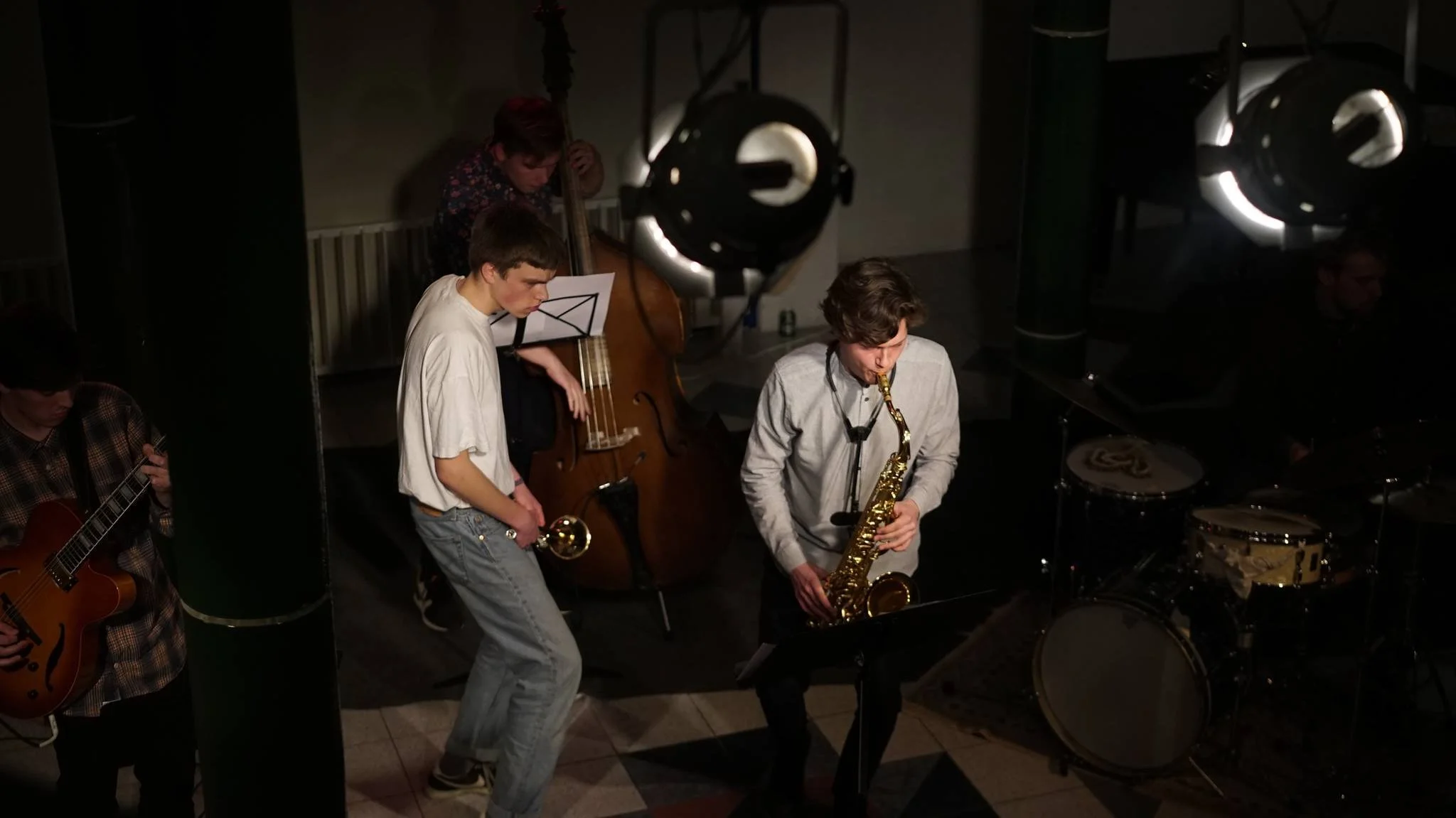A group of musicians playing jazz instruments on stage, including a saxophone, guitar, drums, and bass, during a live performance. Frederik Engell, Peter Price and Carlo Becker