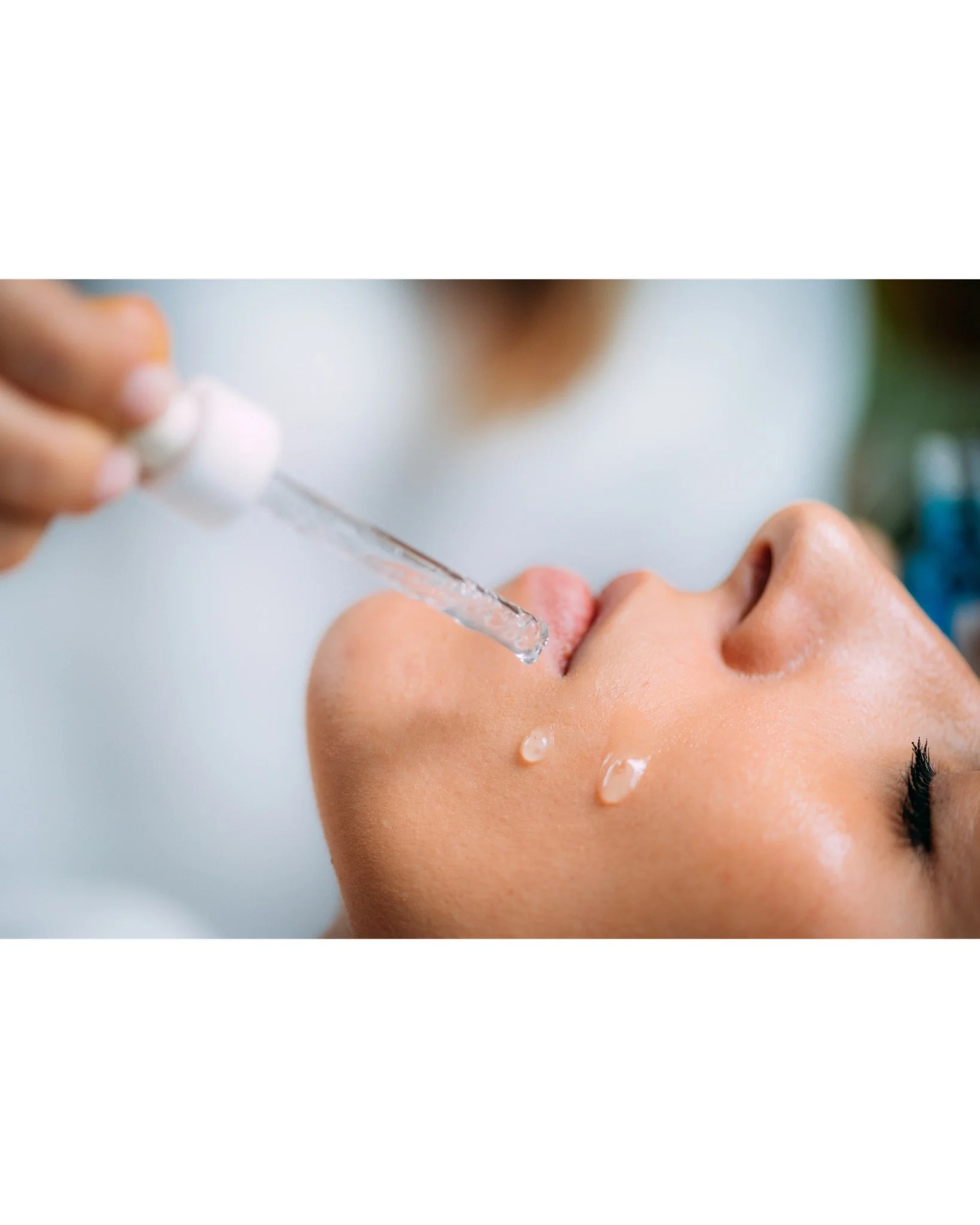 Dropper of serum held near the cheek
