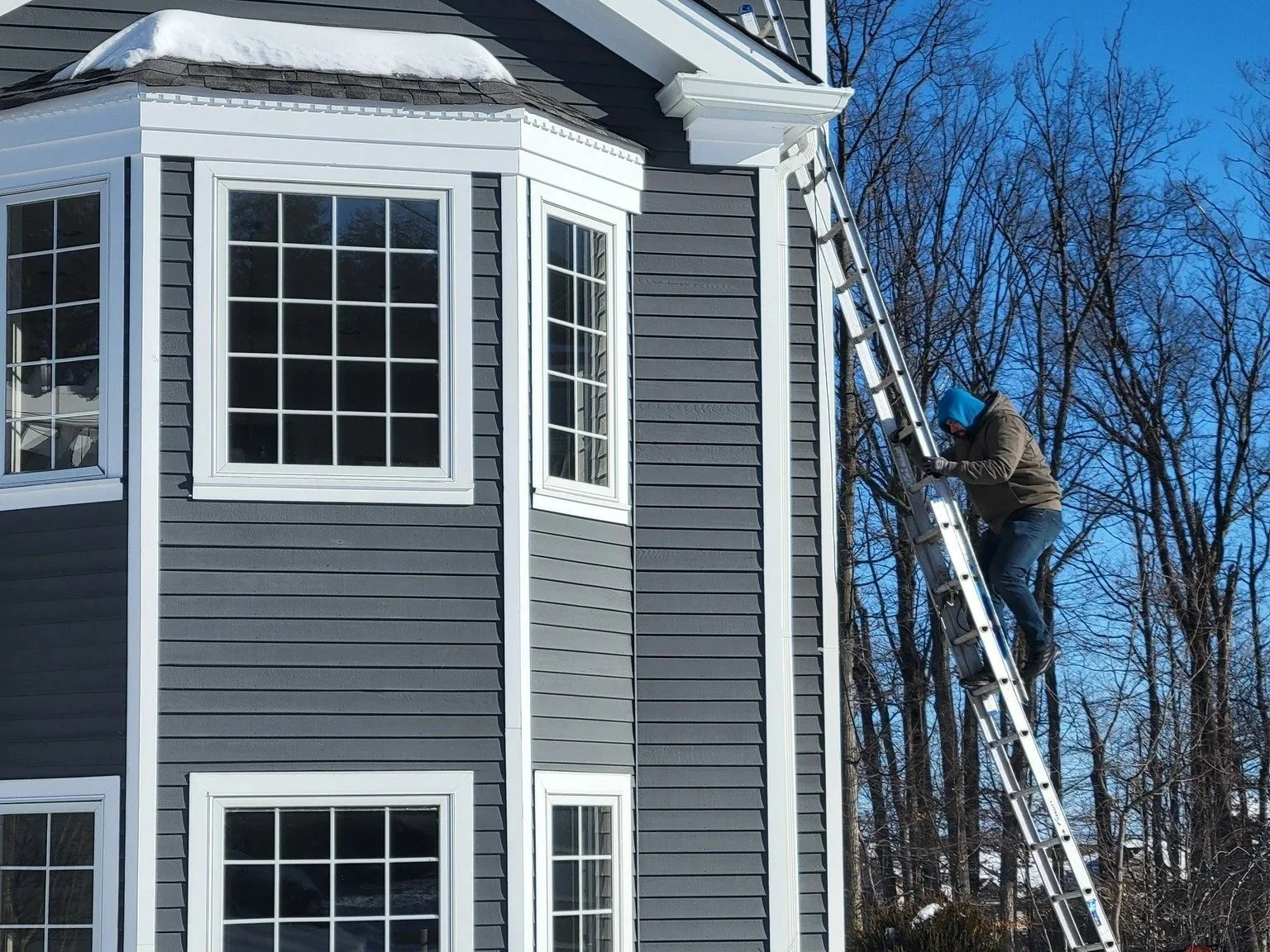 Roof repair in progress—Dave scaling a ladder to access the roof safely for inspection and repairs in North Caldwell, NJ.