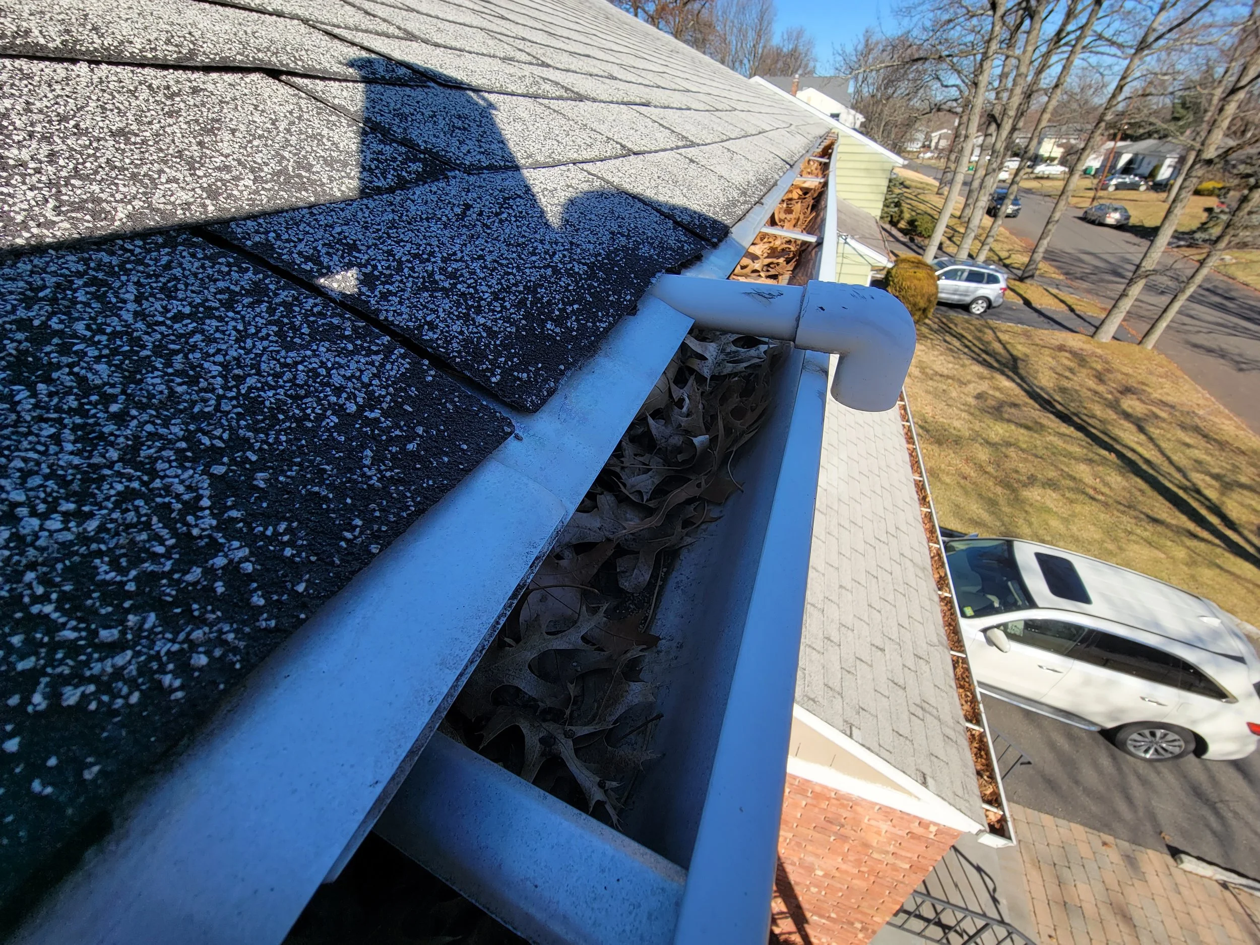 Full gutter on an older roof in Caldwell, NJ during inspection by David Ryan Roofing & Exteriors
