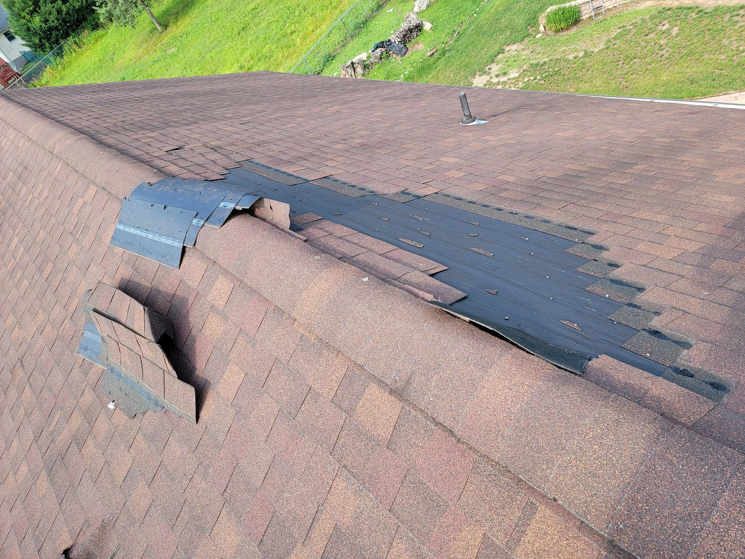 Towaco roof inspection photo showing shingle blow-off from high winds after storm damage.