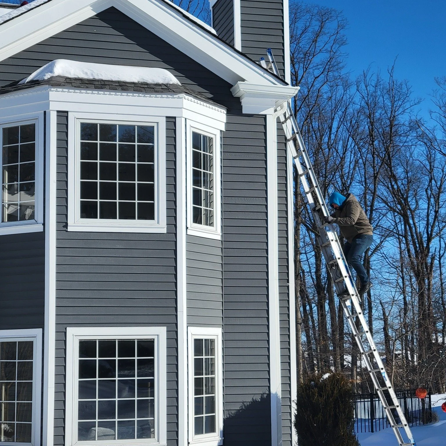 David Ryan scaling a ladder during an ice and snow removal job in North Caldwell, NJ.
