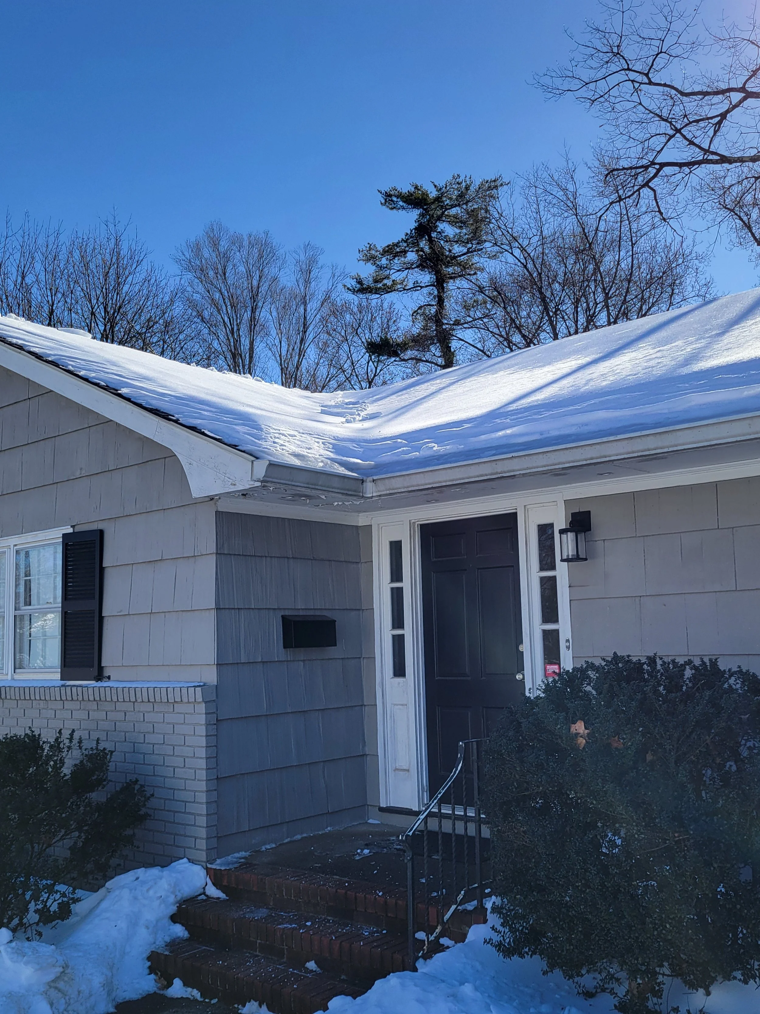 Montclair, NJ—snow-covered roof with ice damming before snow removal and ice dam mitigation.