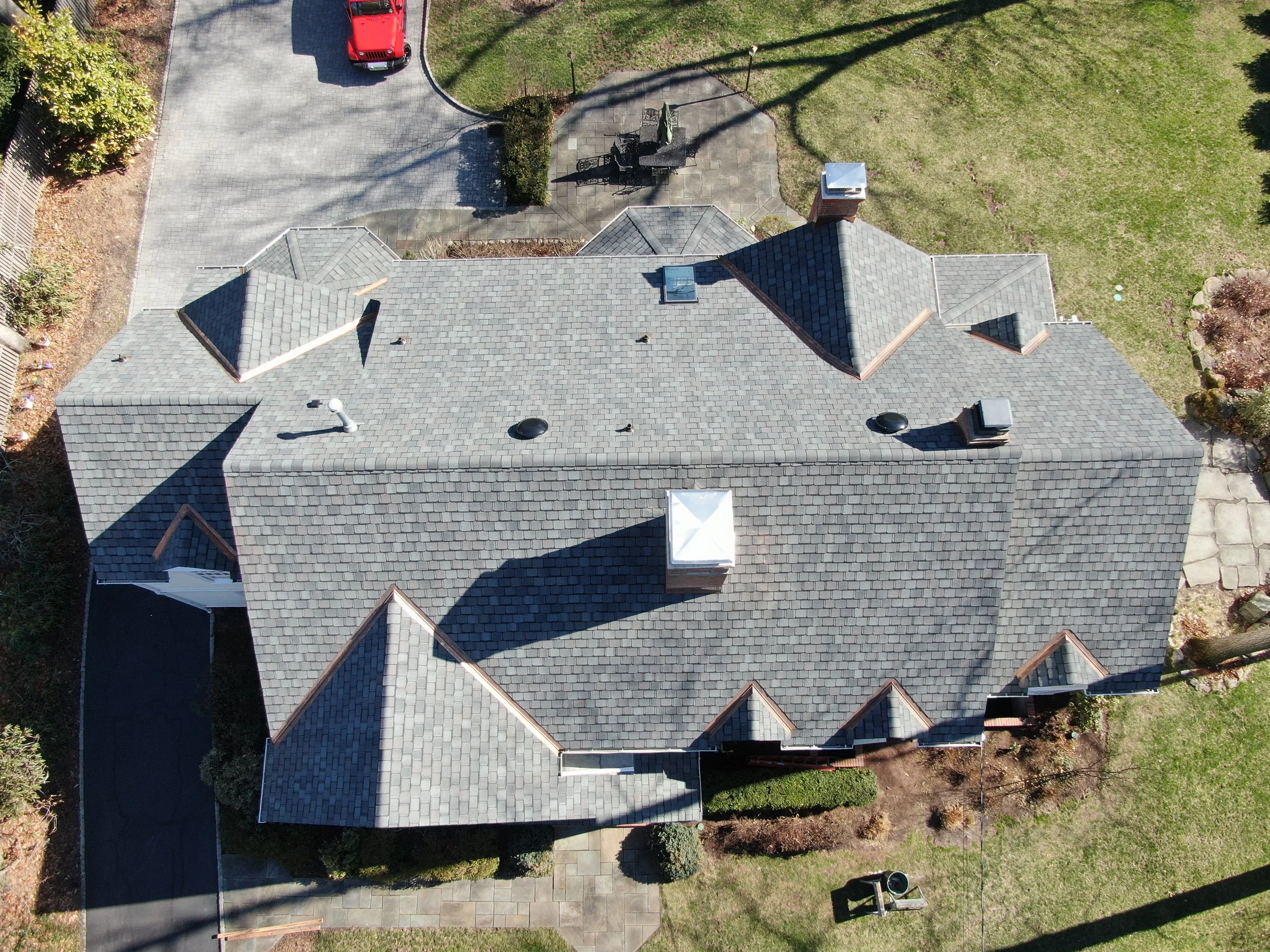 Completed roof replacement—CertainTeed Belmont designer shingles with copper valleys and chimney flashing.