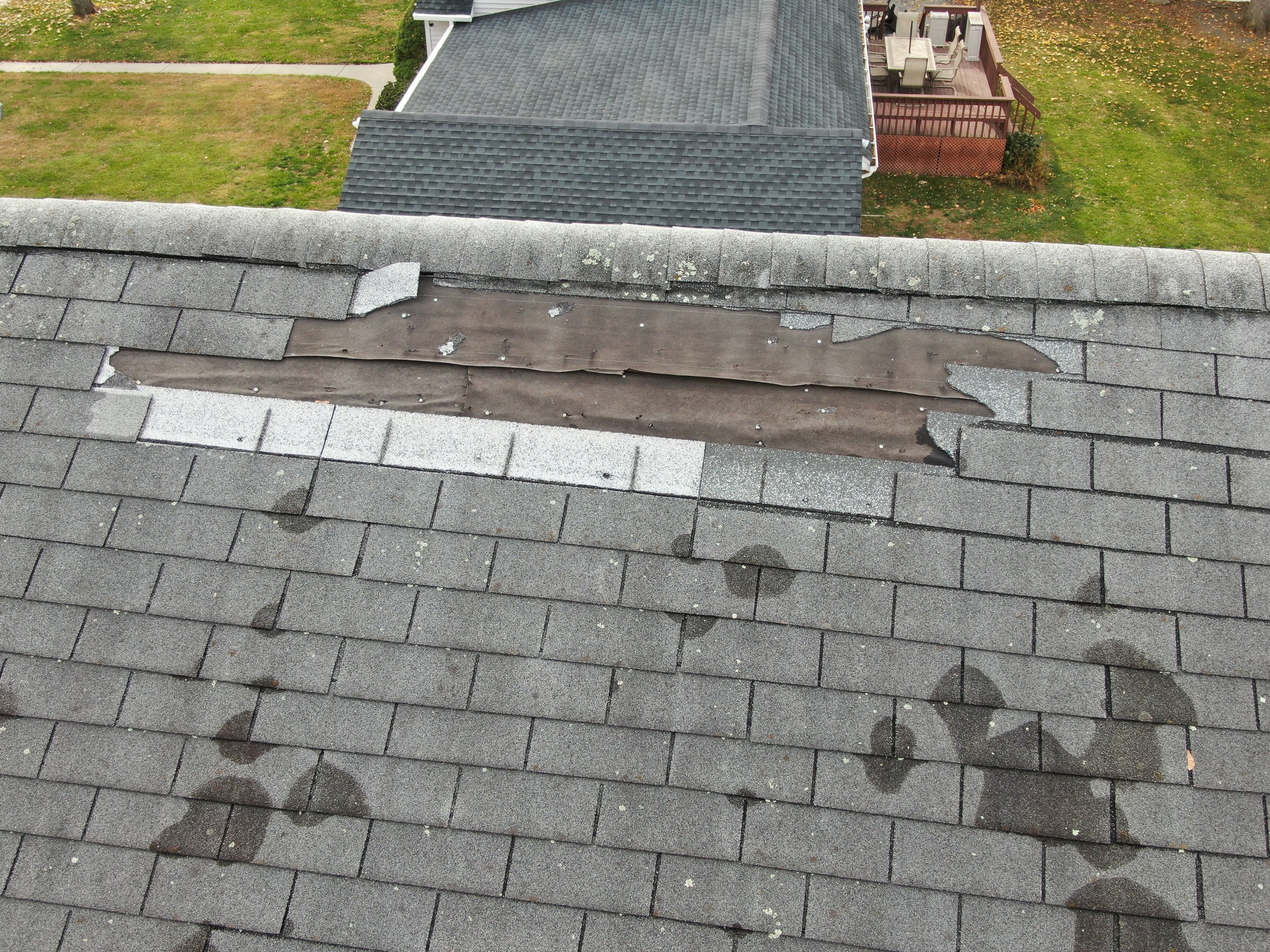 Pompton Plains, NJ—wind damage shingle blow-off after a storm (missing shingles exposed).