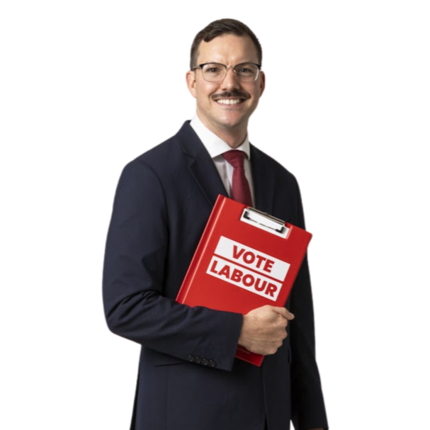 A smiling man in a business suit holding a red folder with the Labour Party logo.