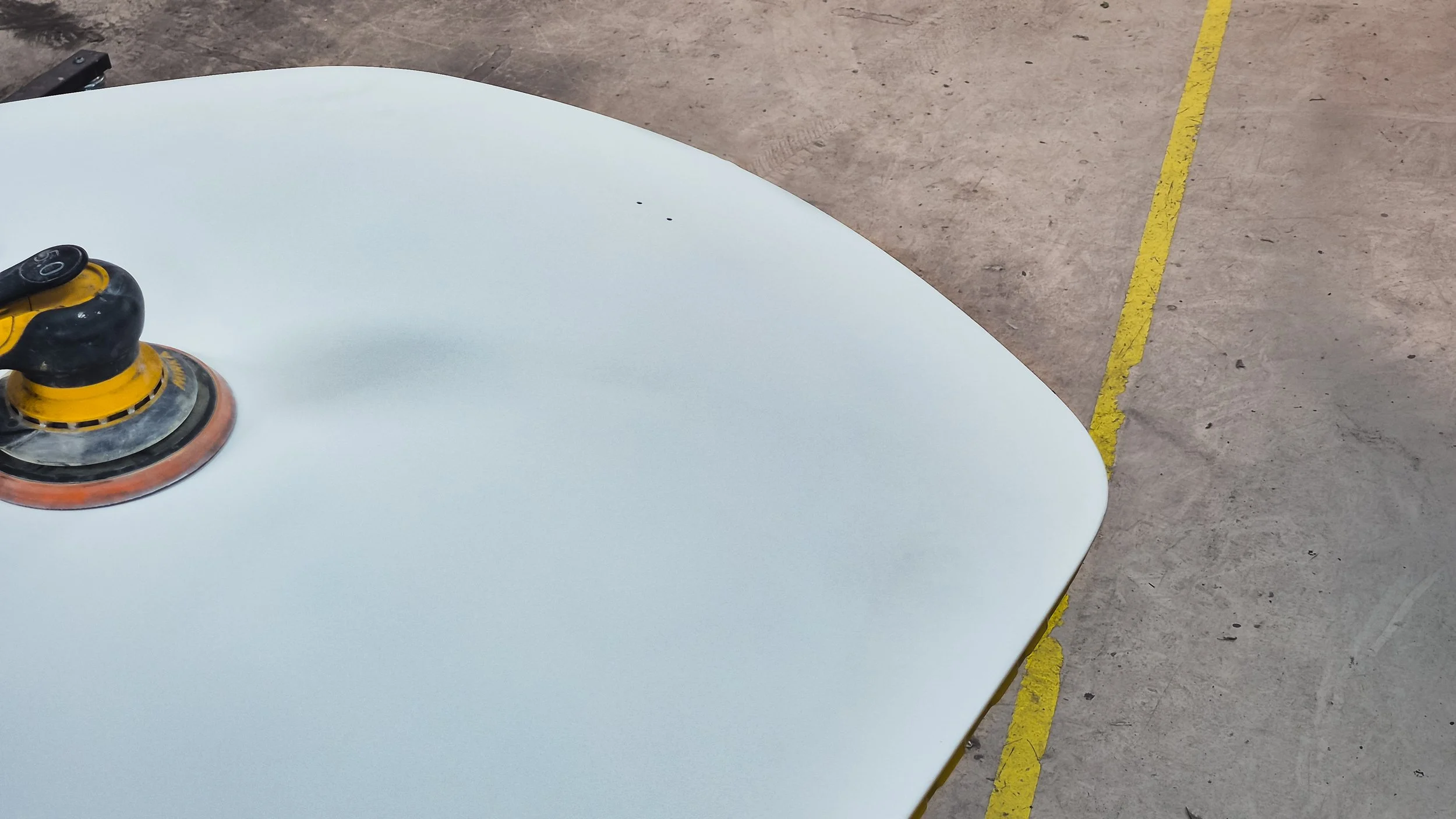 Porsche 911 motorkap voorbereid op het spuiten tijdens schadeherstel.