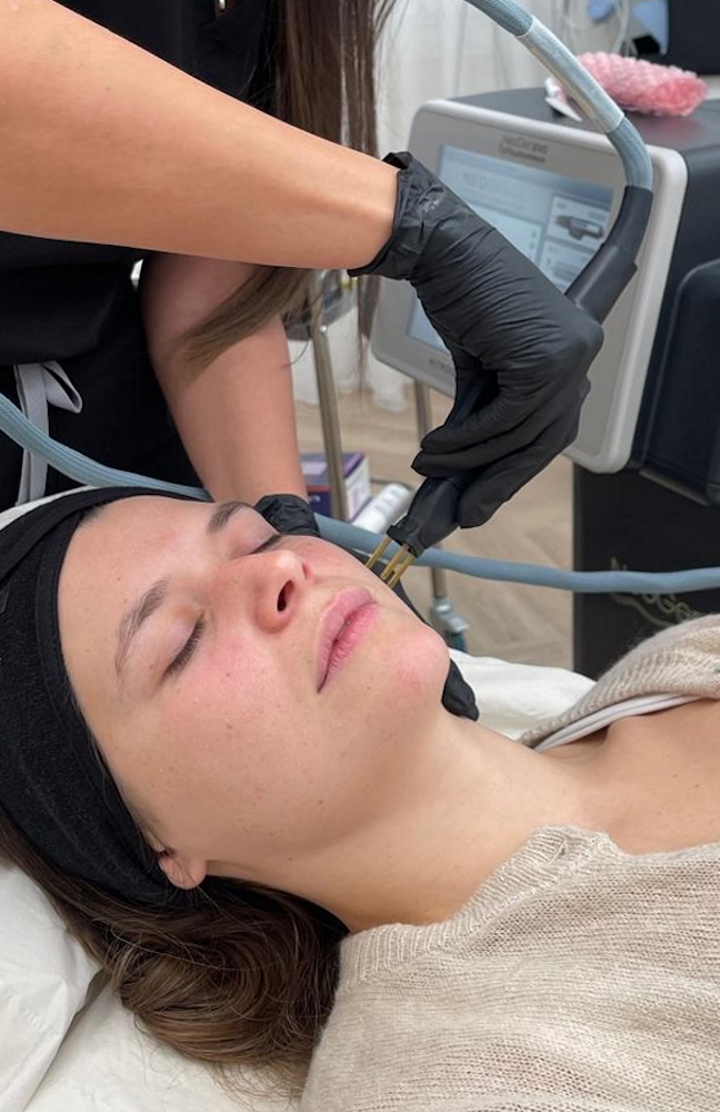Client recieving NeoGen treatment with machine in the background