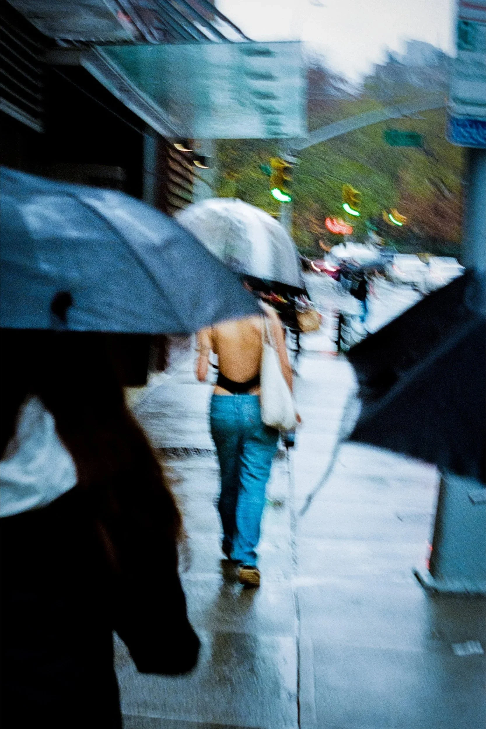 Pedestrians with umbrellas walking on a rainy sidewalk