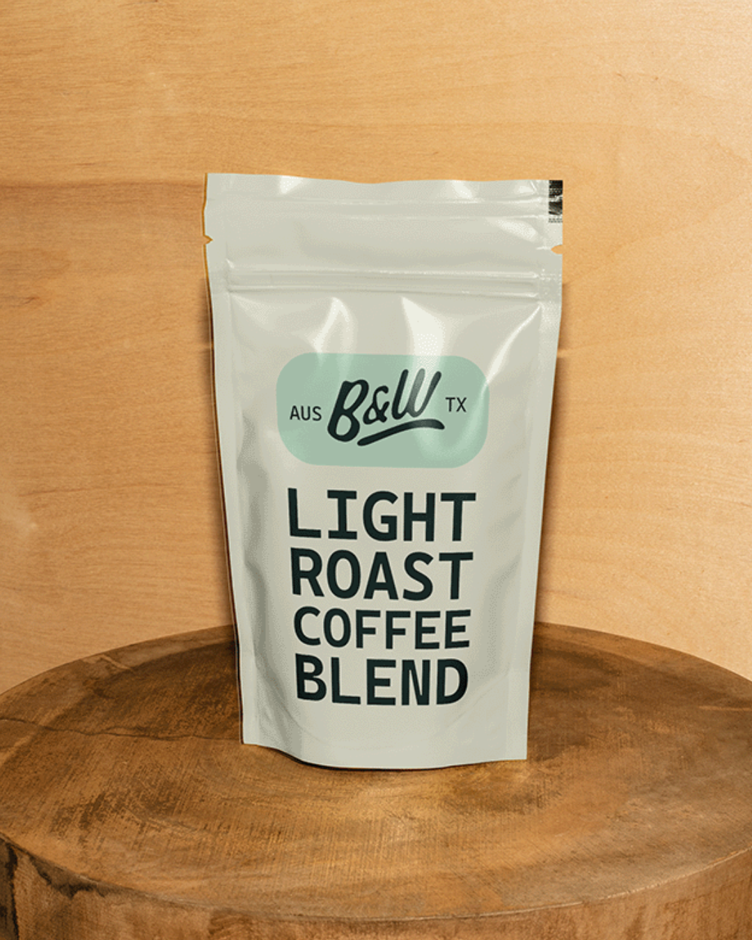 A white bag of light roast coffee blend from Baldy Coffee Co. placed on a wooden surface against a wooden background.