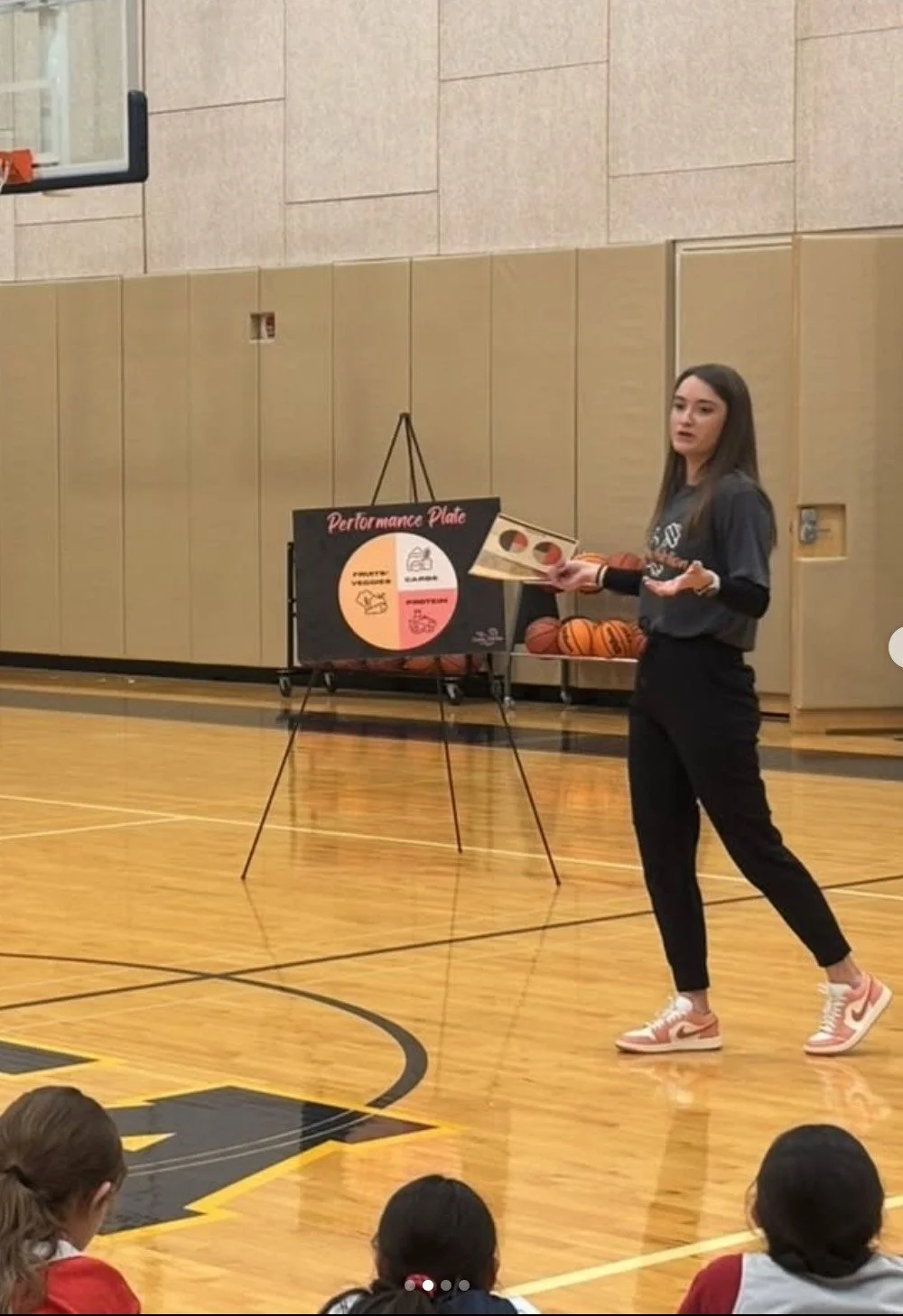 Sarah Bixby, dietitian and owner of Conshy Nutrition, giving a team talk to a girls high school basketball team.