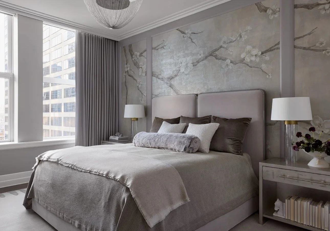 Luxury bedroom interior design in Atlanta featuring a paneled wall with a floral mural, an upholstered bed, and styled nightstands with decor. Soft textures and natural light create a refined, elegant space with a high-end designer aesthetic.