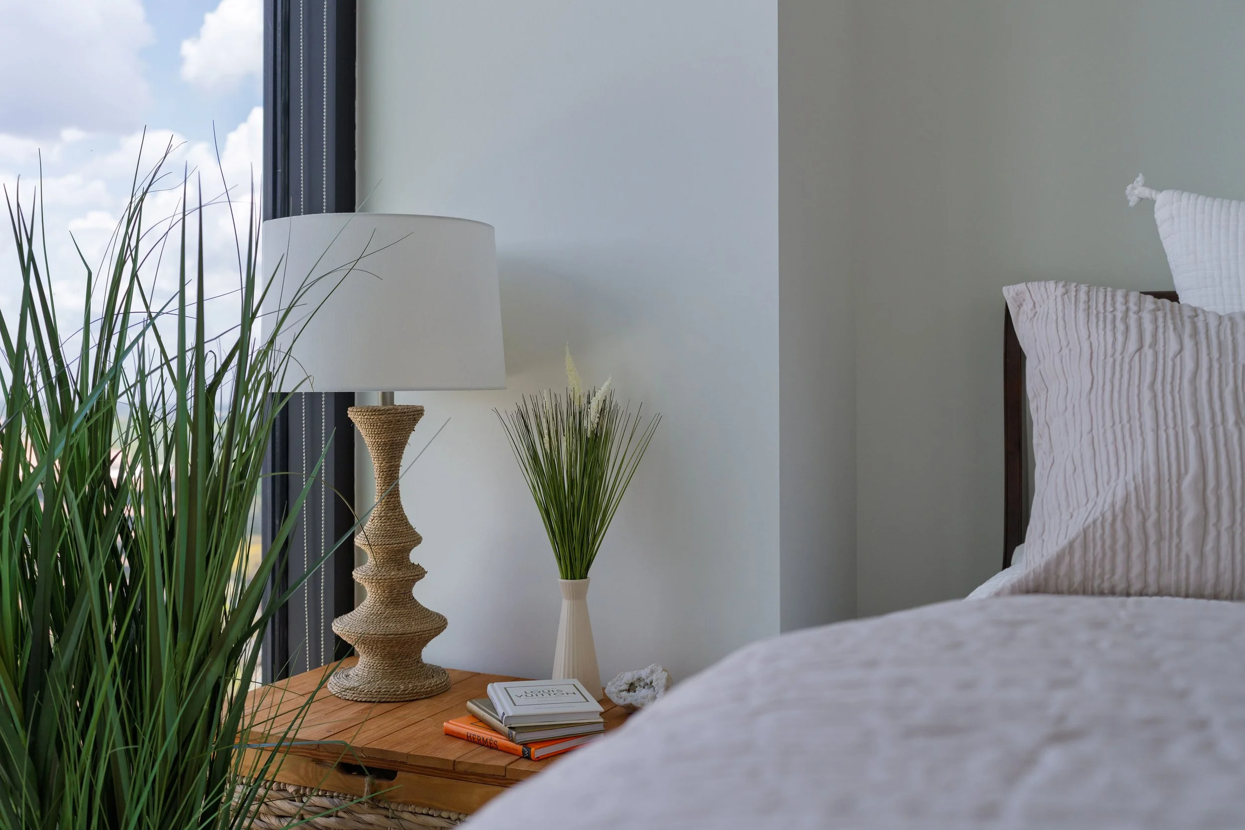 Serene bedroom styling featuring layered textures, soft neutral tones, and curated bedside decor. This space highlights luxury interior styling and restful bedroom design for modern Atlanta homes.