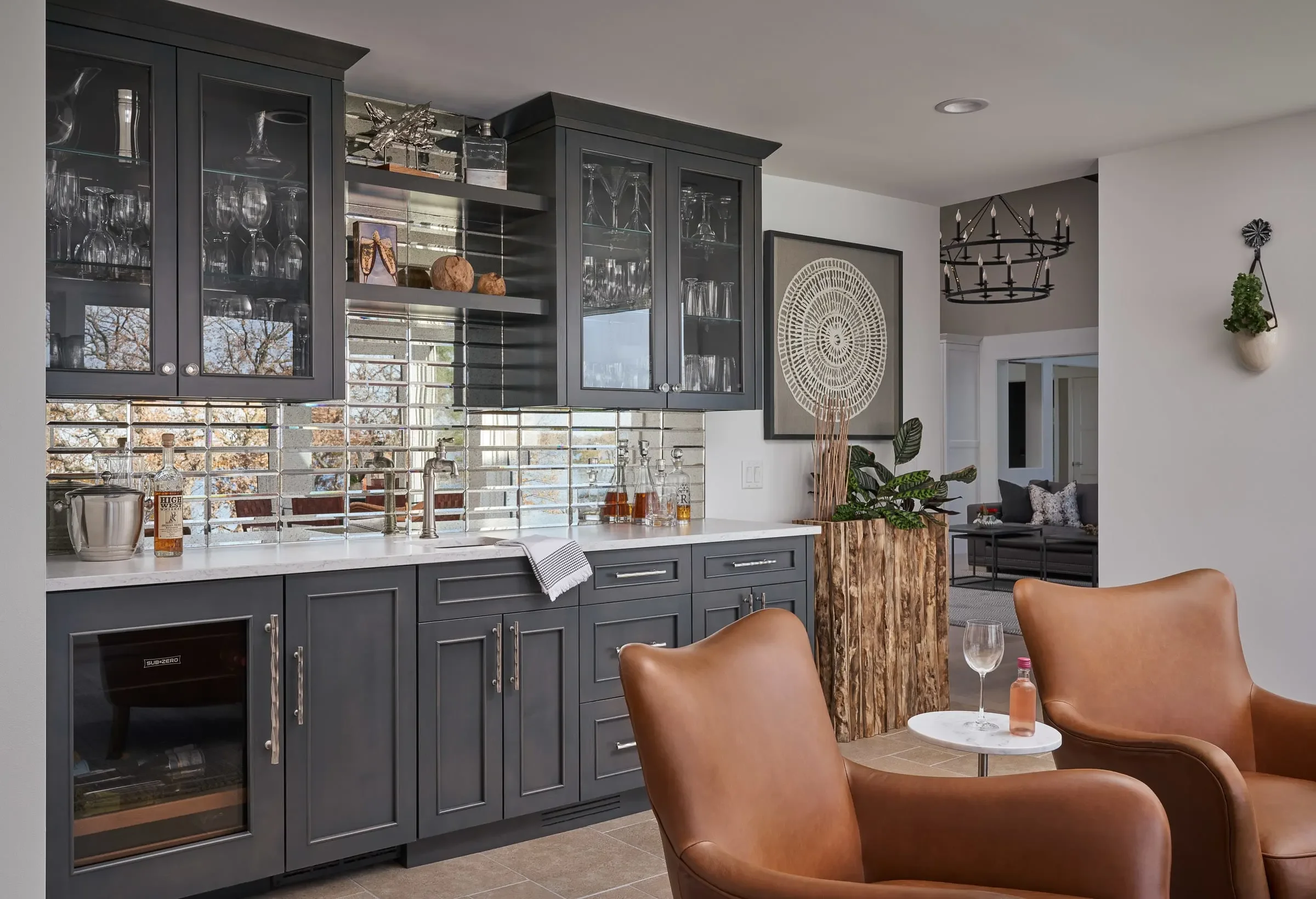 Contemporary kitchen and living space design in Atlanta with dark cabinetry, marble countertops, and open shelving. Styled with modern seating, layered decor, and greenery, this space showcases luxury interior design with a cohesive, open-concept lay