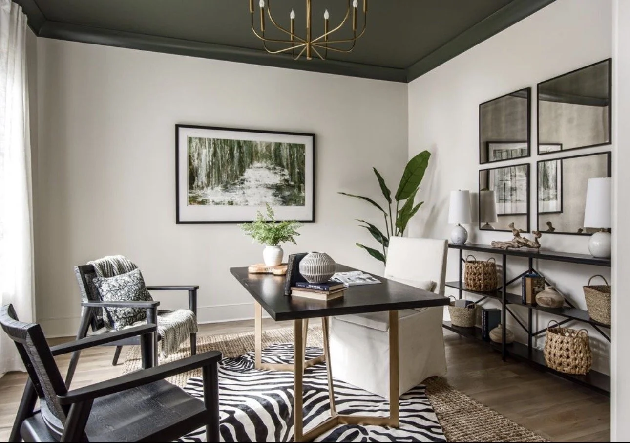 Modern dining room design in Atlanta with a black dining table, mixed seating, and layered textures. Featuring statement decor, a patterned rug, and greenery, this space showcases contemporary interior design with a curated, high-end aesthetic.