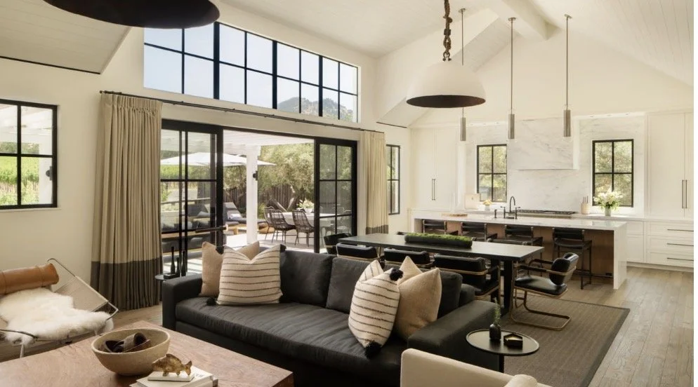 Luxury open-concept living room and kitchen design in Atlanta featuring large windows, sliding glass doors, and modern furnishings. This light-filled space showcases contemporary interior design, seamless indoor-outdoor living, and upscale home styli