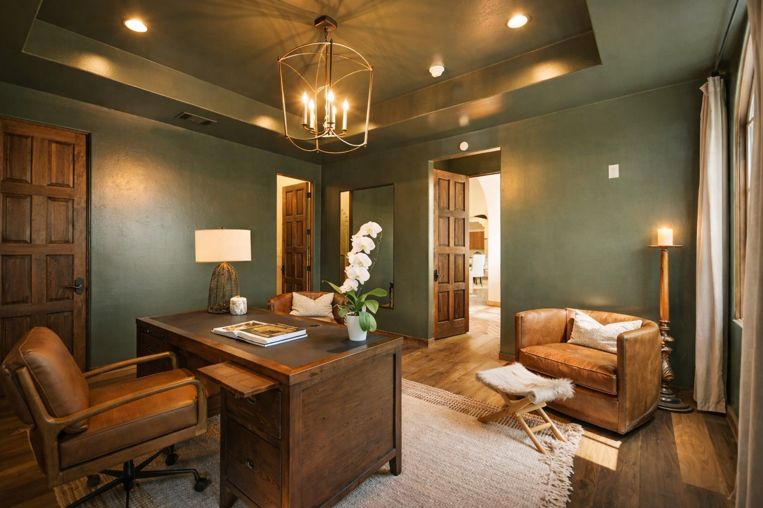 Luxury home office design in Atlanta with green walls, a wooden desk, and a leather chair. Styled with warm lighting, decorative accents, and hardwood floors, this space creates a cozy, elegant, and productive work-from-home environment.