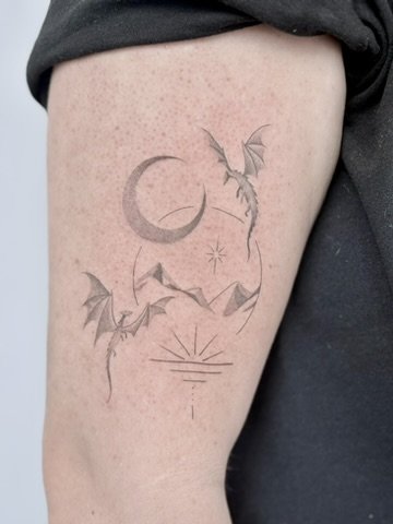 draakjes met maan zon bergen tattoo fineline bovenarm