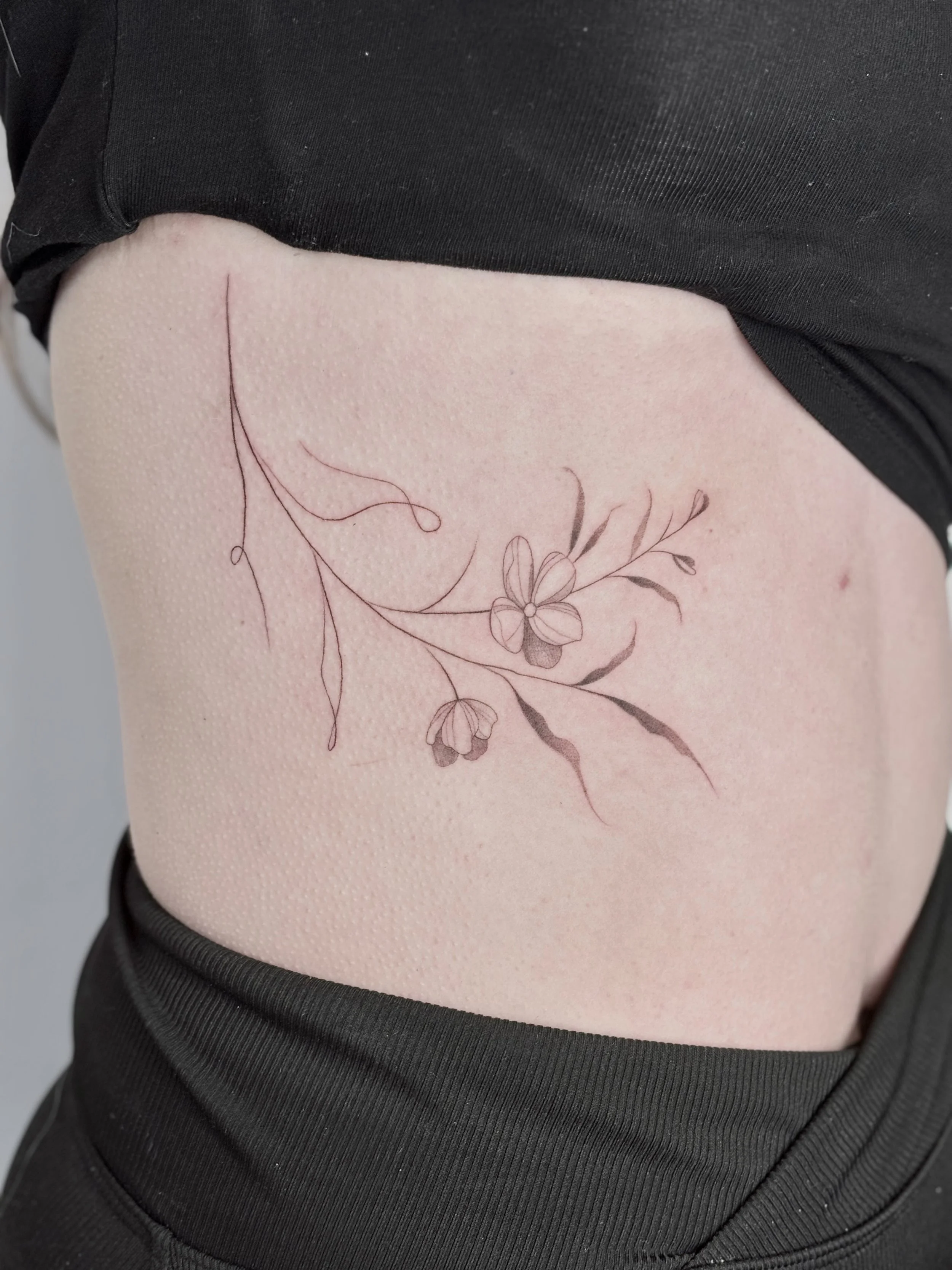 rib tattoo bloemetjes fineline