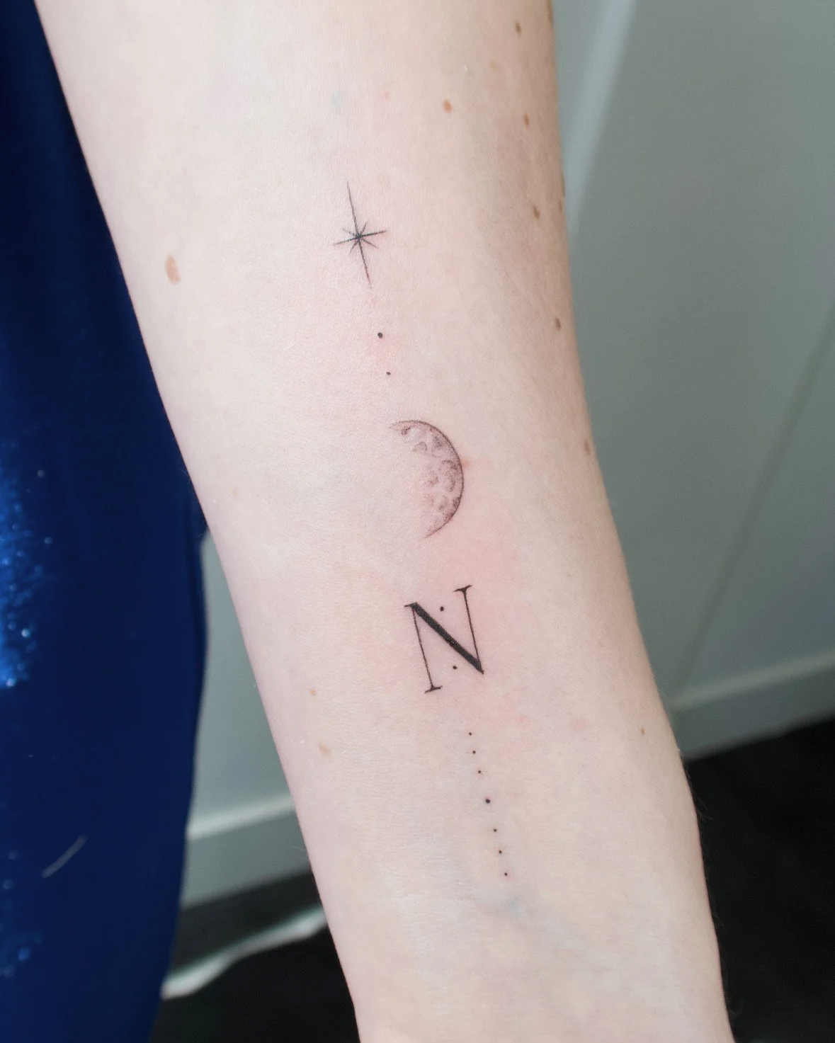 kleine subtiele tattoo fineine maan en letter