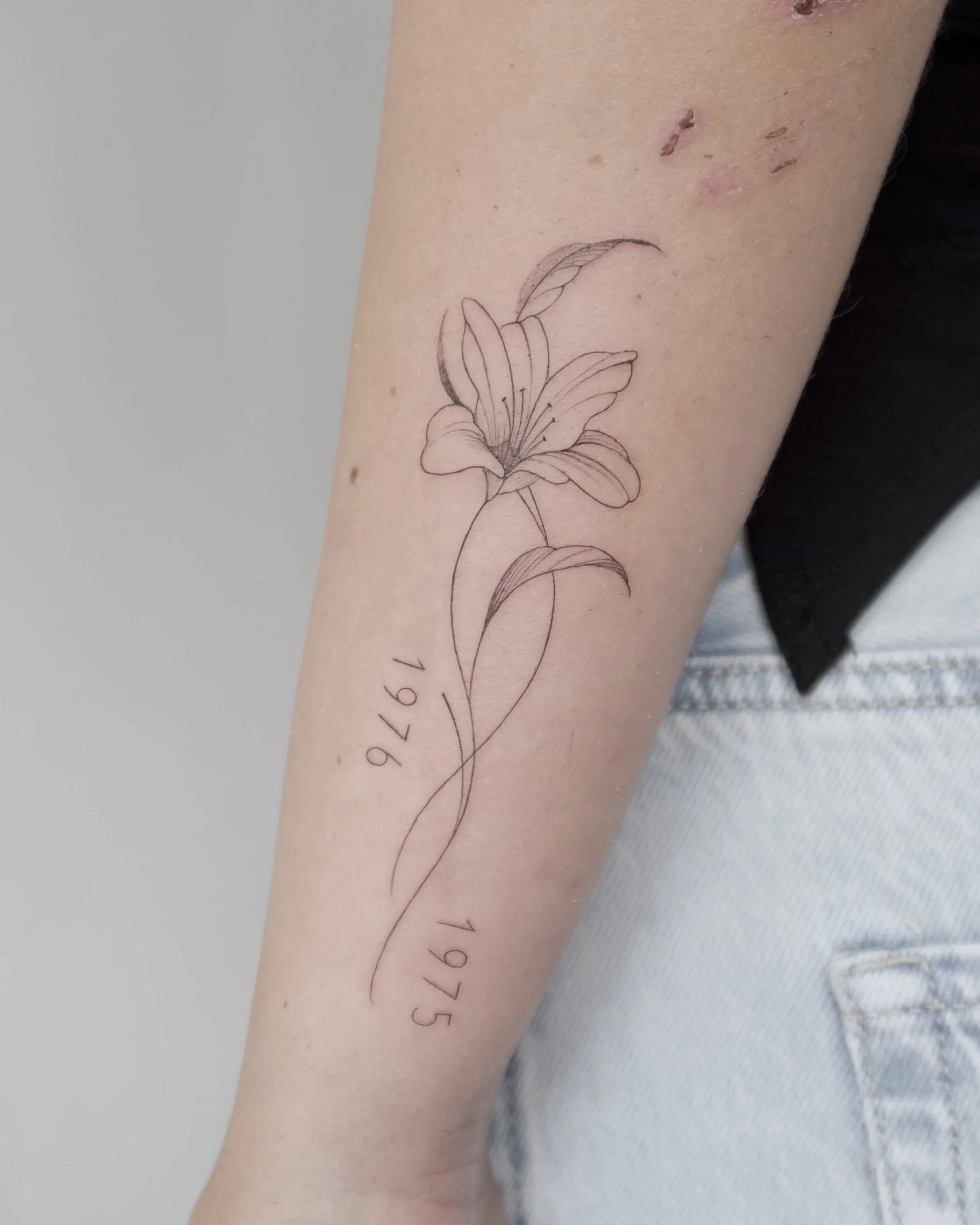 kleine lelie fineline tattoo